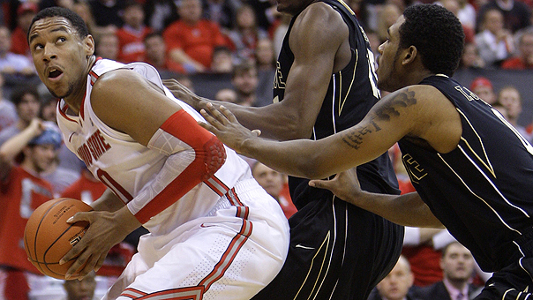 Jan. 25: Ohio State's Jared Sullinger, left, looks for an open shot against Purdue's JaJuan Johnson, center, and Terone Johnson during the second half of an NCAA college basketball game in Columbus, Ohio,