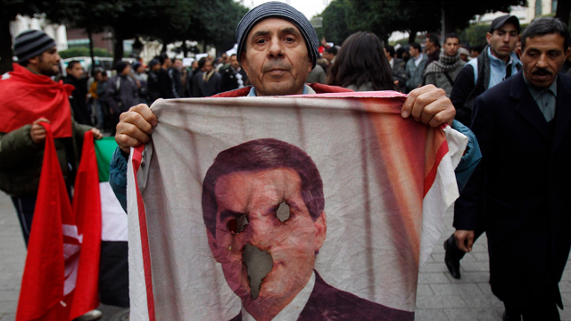 Jan. 25: A protestor holds a burned picture of former Tunisian President Zine El Abidine Ben Ali during a demonstration in Tunis.