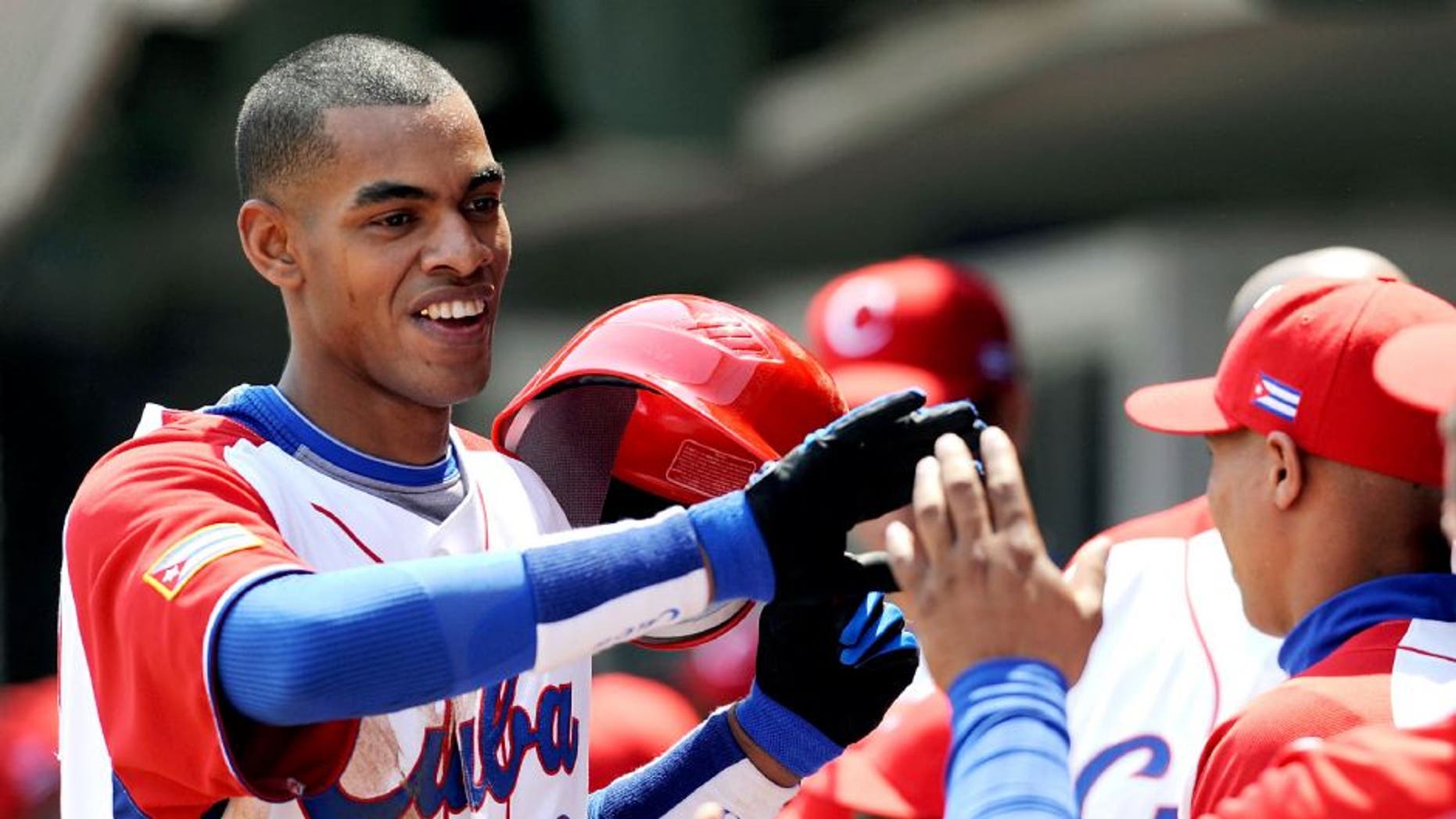 MEXICO CITY - MARCH 08: Hector Olivera #28 of Cuba is congratulated by his teammates after hitting a home run against South Africa during the 2009 World Baseball Classic Pool B match on March 8, 2009 at the Estadio Foro Sol in Mexico City, Mexico. (Photo by Kevork Djansezian/Getty Images) *** Local Caption *** Hector Olivera
