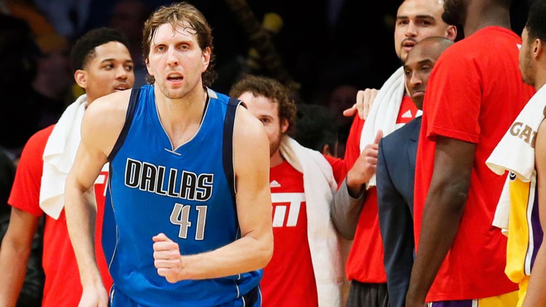 Dallas Mavericks' Dirk Nowitzki, left, runs on the court while Los Angeles Lakers' Kobe Bryant, right, reacts to Nowitzki making a shot over Lakers' Julius Randle, not seen, to give the Mavericks the lead in the closing seconds of an NBA basketball game Tuesday, Jan. 26, 2016, in Los Angeles. The Mavericks won 92-90. (AP Photo/Danny Moloshok)
