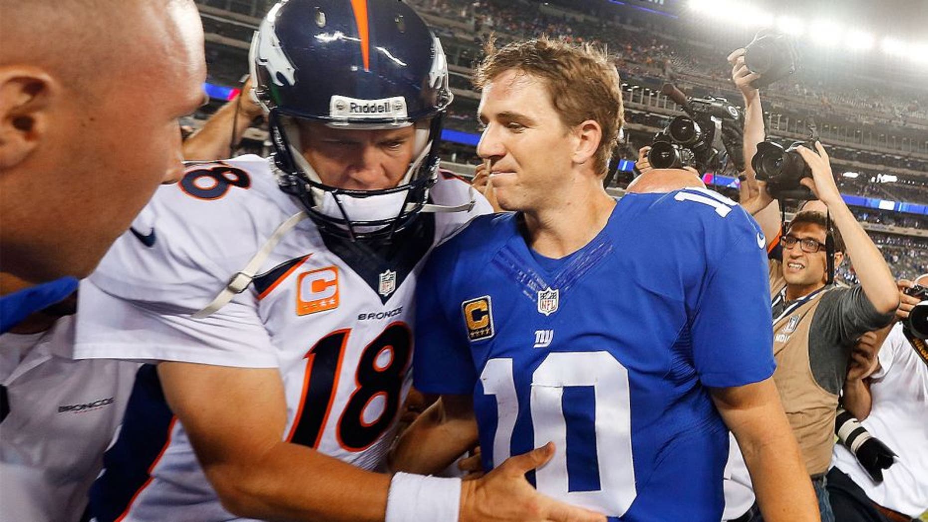 EAST RUTHERFORD, NJ - SEPTEMBER 15: (NEW YORK DAILIES OUT) Quarterbacks Peyton Manning #18 of the Denver Broncos and Eli Manning #10 of the New York Giants meet after their game on September 15, 2013 at MetLife Stadium in East Rutherford, New Jersey. The Broncos defeated the Giants 41-23. (Photo by Jim McIsaac/Getty Images) *** Local Caption *** Peyton Manning; Eli Manning