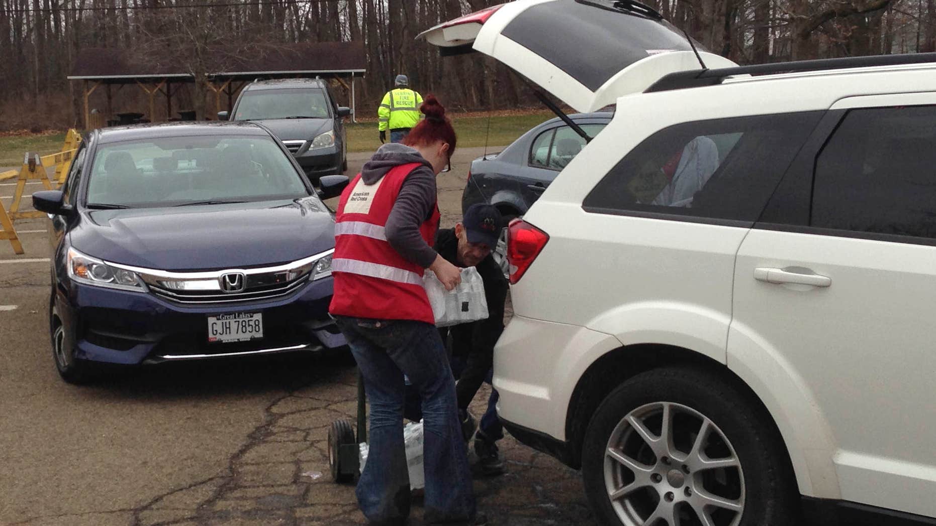 People line up and load water into cars Tuesday, Jan. 26, 2016 in Sebring, Ohio.