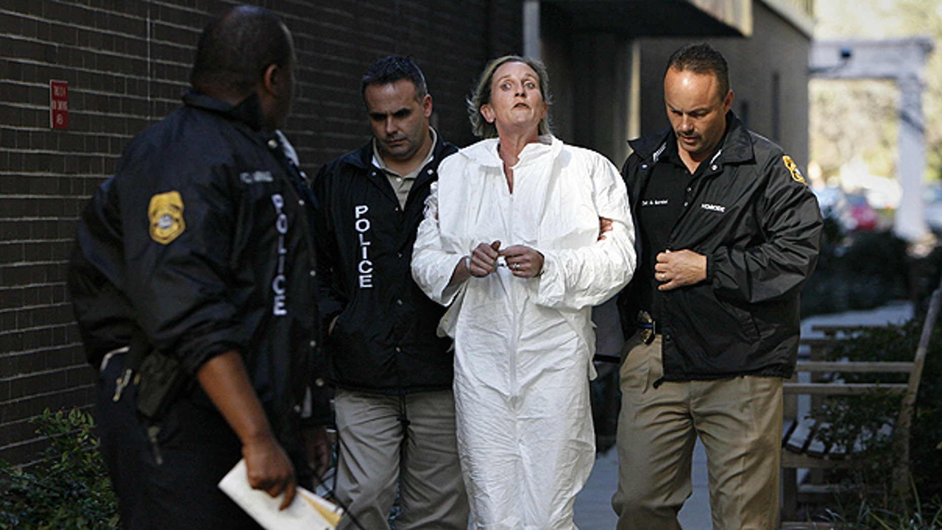 Jan. 28: Tampa Police officer escorts Julie Powers Schenecker to Orient Road Jail in Tampa, Fla.