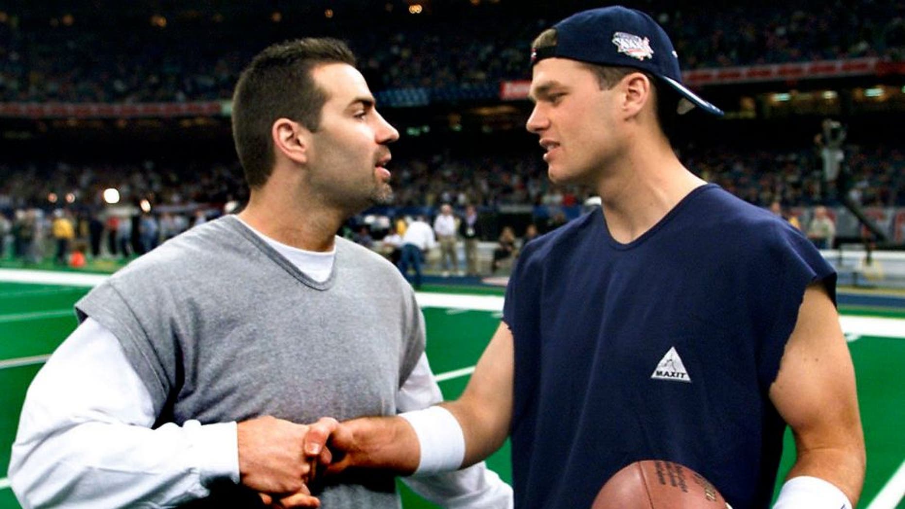 NEW ORLEANS, UNITED STATES: New England Patriots quarterback Tom Brady (R) chats with St. Louis Rams quarterback Kurt Warner (L) 03 February, 2002 at the Louisiana Superdome before Super Bowl XXXVI in New Orleans, Louisiana. The St. Louis Rams and the New England Patriots are playing for the NFL championship. AFP PHOTO/Jeff HAYNES. (Photo credit should read JEFF HAYNES/AFP/Getty Images)
