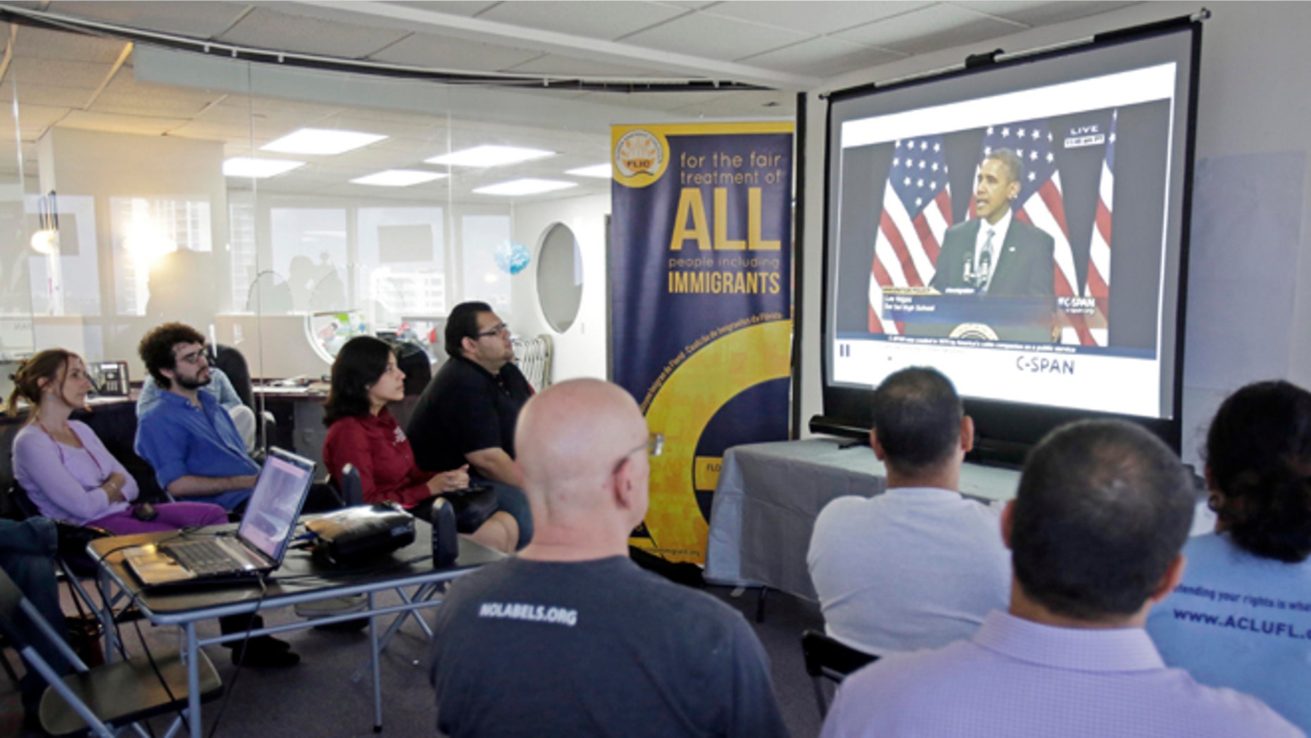 Jan. 29, 2013: Illegal immigrants and immigration activists watch a live image of President Barack Obama speaking about immigration reform as they sit together in Miami.