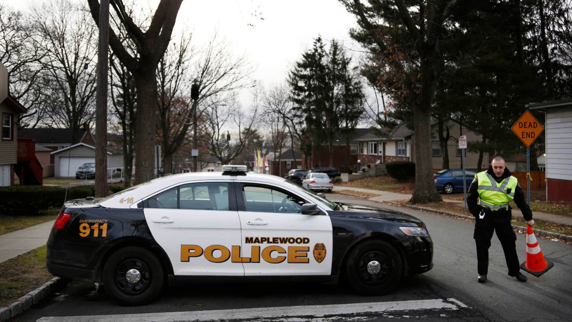 A police officers blocks the entrance to Van Ness Court in Maplewood, N.J., Monday, Jan. 30, 2017, the day after three people were found dead in an apartment there.