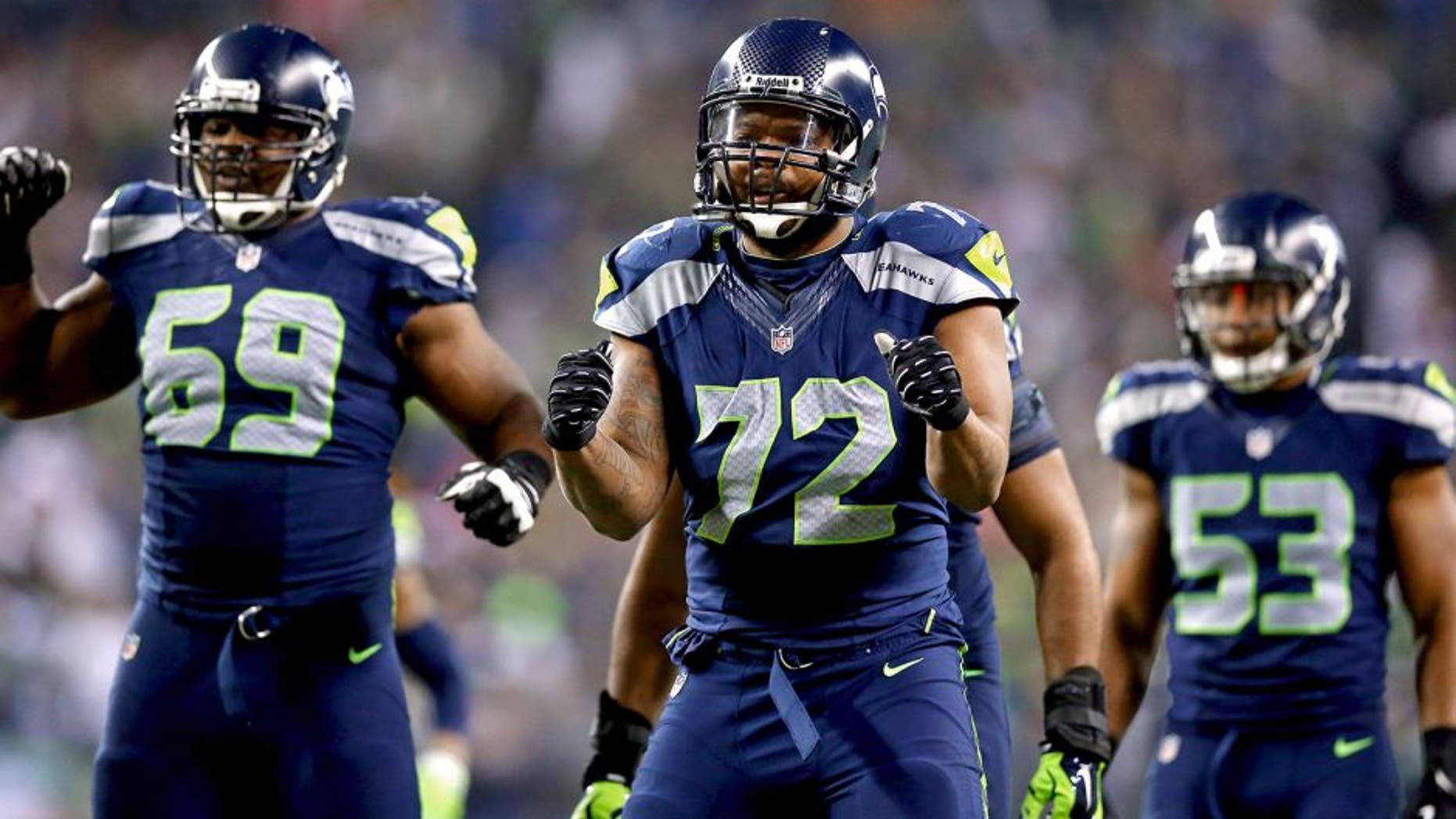 SEATTLE, WA - JANUARY 19: Defensive end Michael Bennett #72 of the Seattle Seahawks and defensive tackle Clinton McDonald #69 react against the San Francisco 49ers during the 2014 NFC Championship at CenturyLink Field on January 19, 2014 in Seattle, Washington. (Photo by Ronald Martinez/Getty Images)