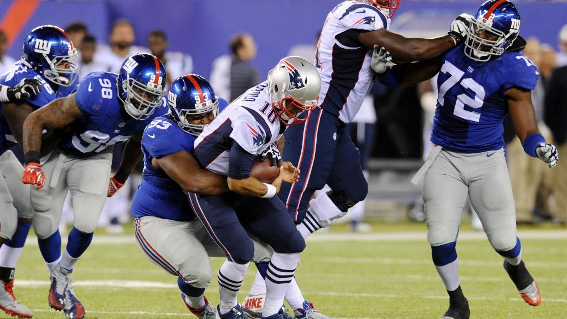 New York Giants' Mike Patterson, third from left, sacks New England Patriots quarterback Jimmy Garoppolo during the first half of an NFL preseason football game, Thursday, Aug. 28, 2014, in East Rutherford, N.J. (AP Photo/Bill Kostroun)