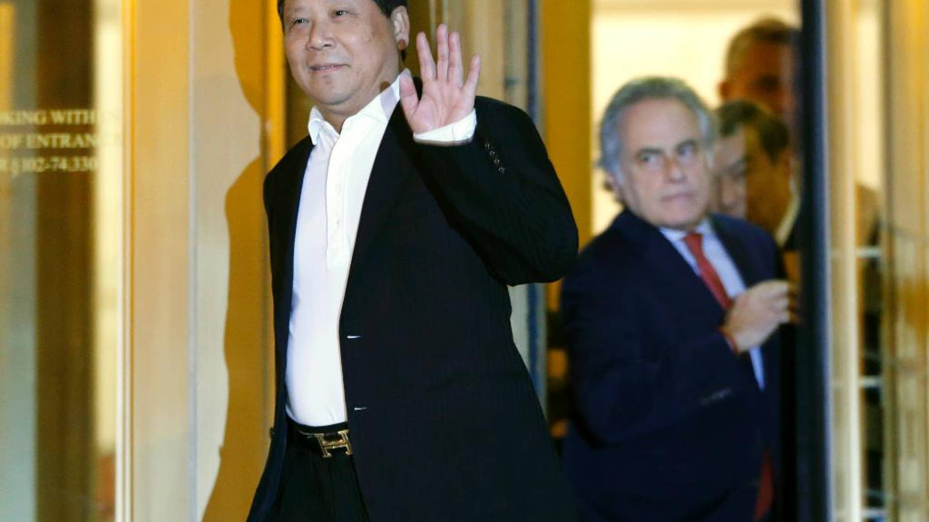 FILE- In this Oct. 26, 2015 file photo, Chinese billionaire Ng Lap Seng waves to the media as he leaves federal court after he was released on bail in connection with a United Nations bribery scheme in New York. Jurors in Ng's trial should know he was referred to as the "boss" by co-conspirators, prosecutors said Friday, Dec. 30, 2016, as they argued that defense lawyers were "far-fetched" to say the word suggests organized crime. (AP Photo/Kathy Willens, File)