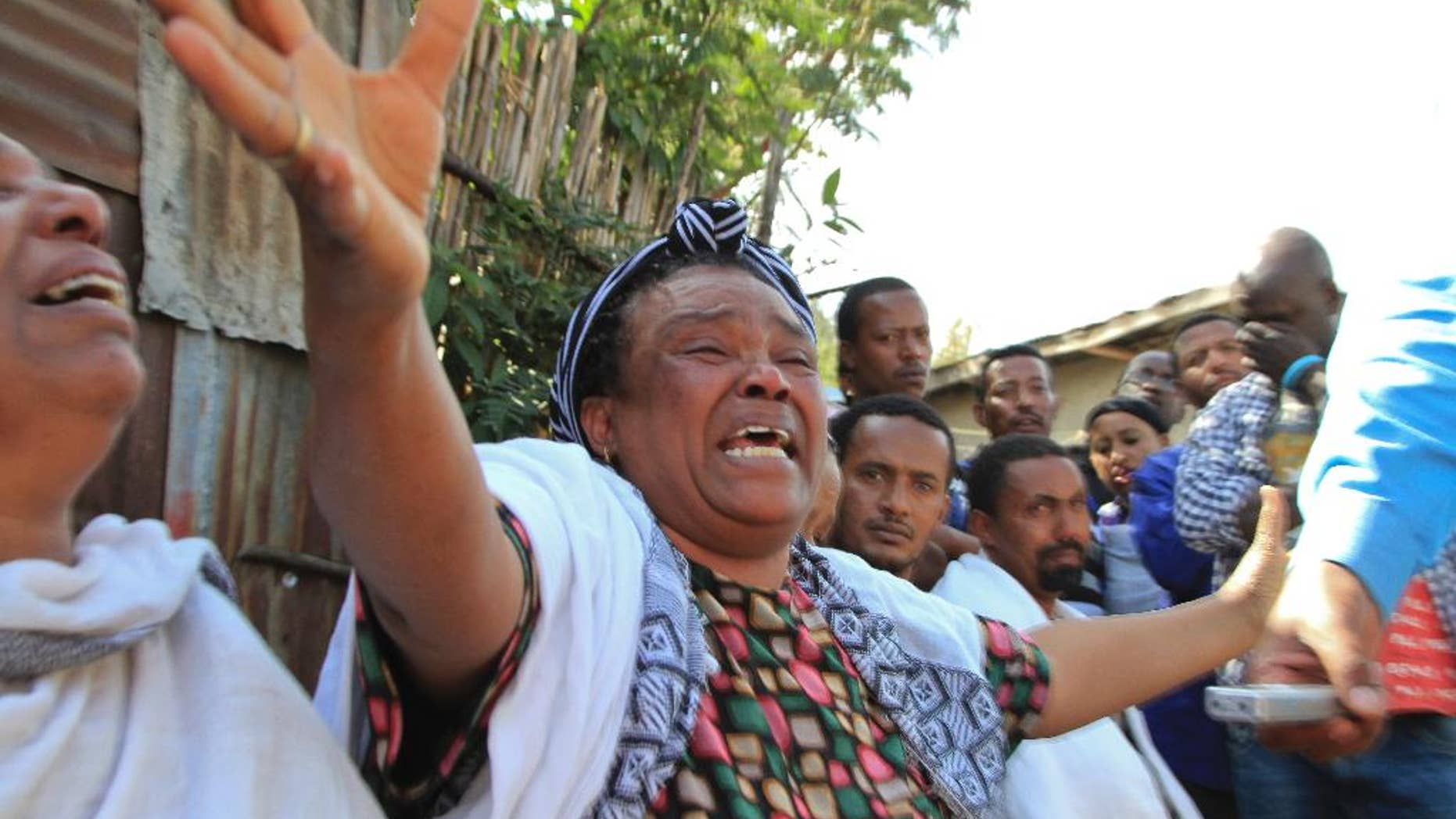 Unidentified relatives and friends mourn for the Ethiopians who were were held captive in Libya and killed by the Islamic State group, in the poor Cherkos Village neighborhood of Addis Ababa, Ethiopia Monday, April 20, 2015. Many in Ethiopia are reeling from the news that several Ethiopians were killed in Libya by the Islamic State group, which over the weekend released a video purporting to show the killings that has shocked many in the predominantly Christian country where some on Monday gathered in an Addis Ababa slum to mourn two former residents whose faces were recognized in the Islamic State video. (AP Photo)