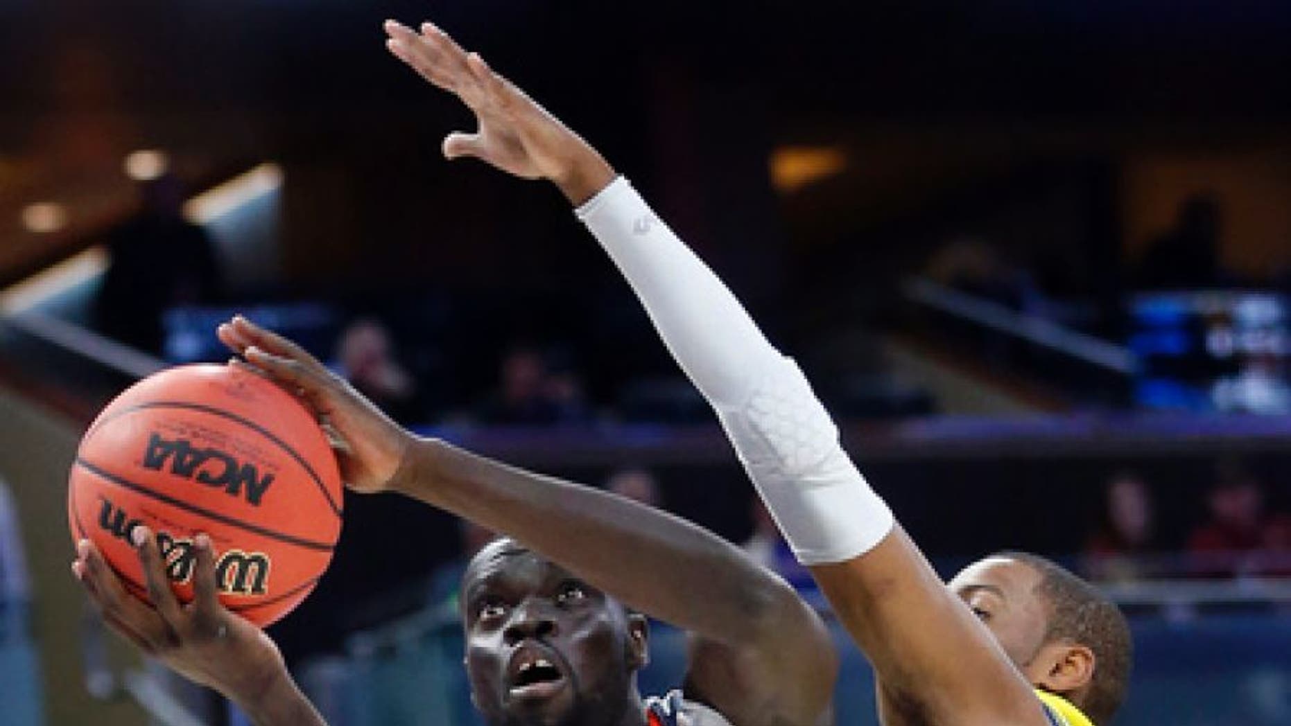 Virginia guard Marial Shayok (4) goes up for a shot against UNC Wilmington guard Chris Flemmings during the first half of a first-round men's college basketball game in the NCAA Tournament, Thursday, March 16, 2017, in Orlando, Fla. (AP Photo/Wilfredo Lee)