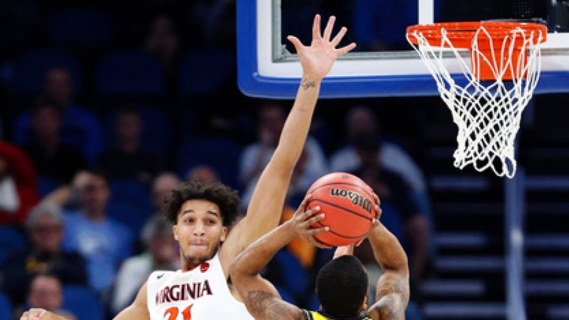 UNC Wilmington guard Jordon Talley (4) goes up for a shot against Virginia forward Isaiah Wilkins (21) and guard Devon Hall during the first half of a first-round men's college basketball game in the NCAA Tournament, Thursday, March 16, 2017, in Orlando, Fla. Virginia defeated UNC Wilmington 76-71. (AP Photo/Wilfredo Lee)