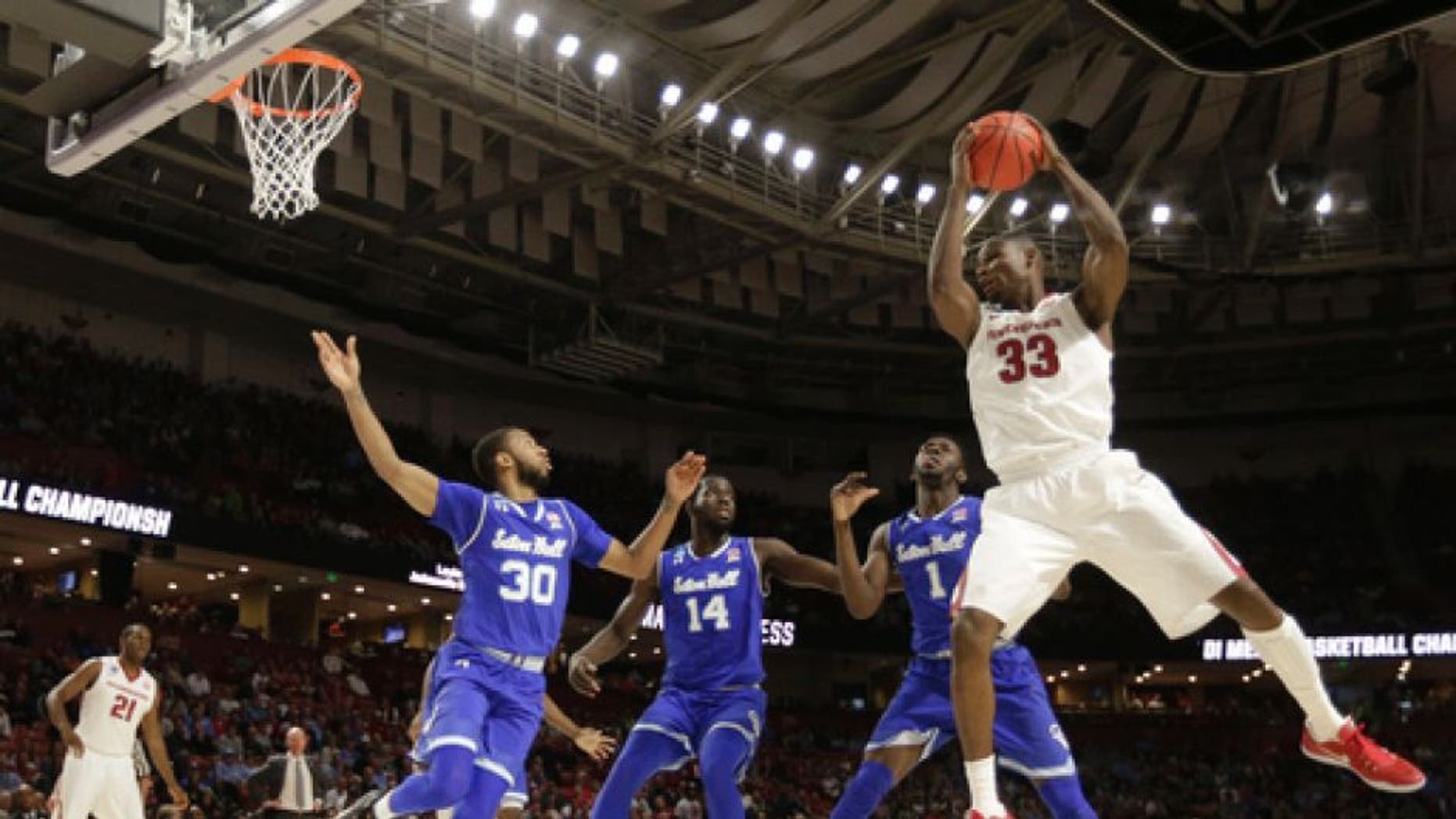 Arkansas's Moses Kingsley (33) grabs a rebound against Seton Hall players Madison Jones (30), Ismael Sanogo (14) and Michael Nzei (1) during the first half in a first-round game of the NCAA men's college basketball tournament in Greenville, S.C., Friday, March 17, 2017. (AP Photo/Chuck Burton)