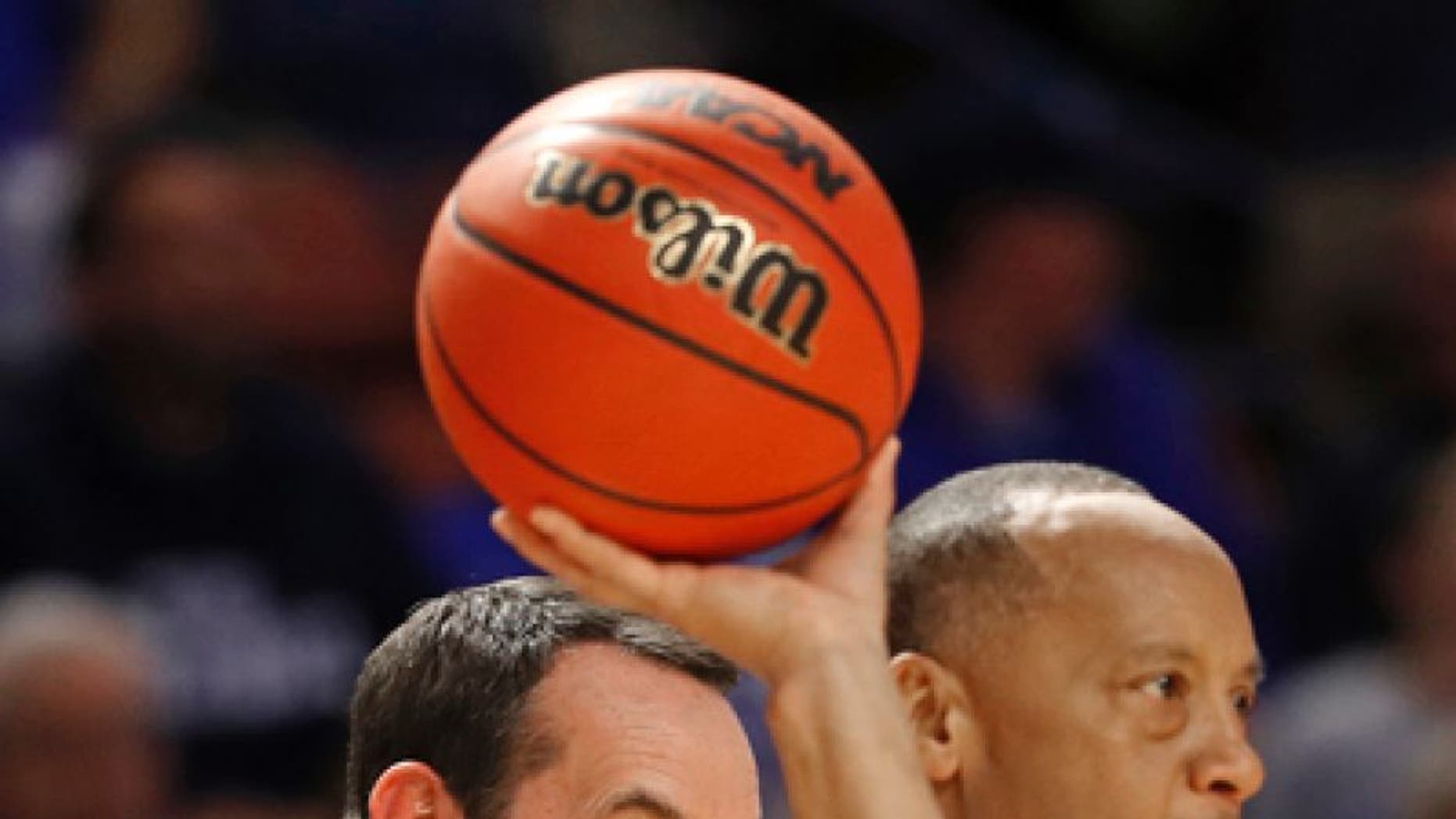 Duke head coach Mike Krzyzewski, left, argues a call with an official during the second half against Troy in a first-round game of the NCAA men's college basketball tournament in Greenville, S.C., Friday, March 17, 2017. (AP Photo/Chuck Burton)