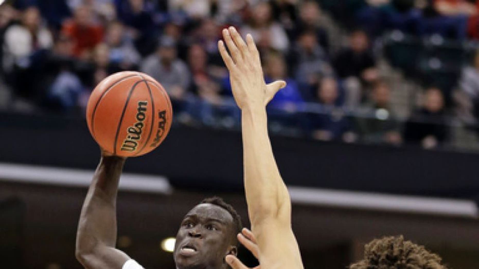 Louisville forward Deng Adel (22) goes up for a dunk over Michigan forward D.J. Wilson (5) during the first half of a second-round game in the mens NCAA college basketball tournament in Indianapolis, Sunday, March 19, 2017. (AP Photo/Michael Conroy)