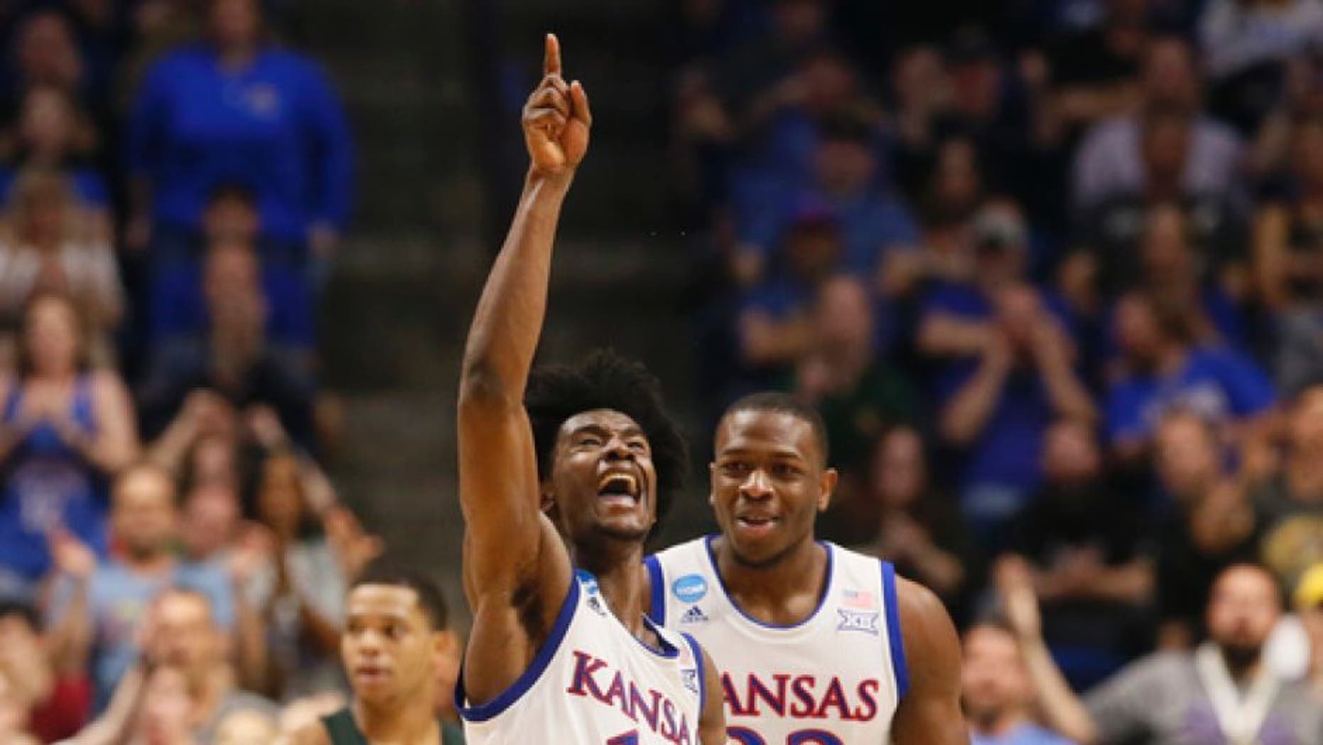 Kansas guard Josh Jackson (11) celebrates a basket with teammate Dwight Coleby (22) in front of Michigan State guard Miles Bridges (22) in the second half of a second-round game in the men's NCAA college basketball tournament in Tulsa, Okla., Sunday, March 19, 2017. (AP Photo/Sue Ogrocki)
