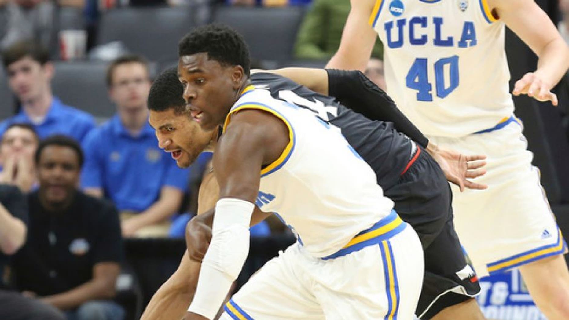 UCLA guard Aaron Holiday, front, comes up with the ball against Cincinnati guard Jarron Cumberland during the first half of a second-round game of the NCAA men's college basketball tournament in Sacramento, Calif., Sunday, March 19, 2017. (AP Photo/Steve Yeater)