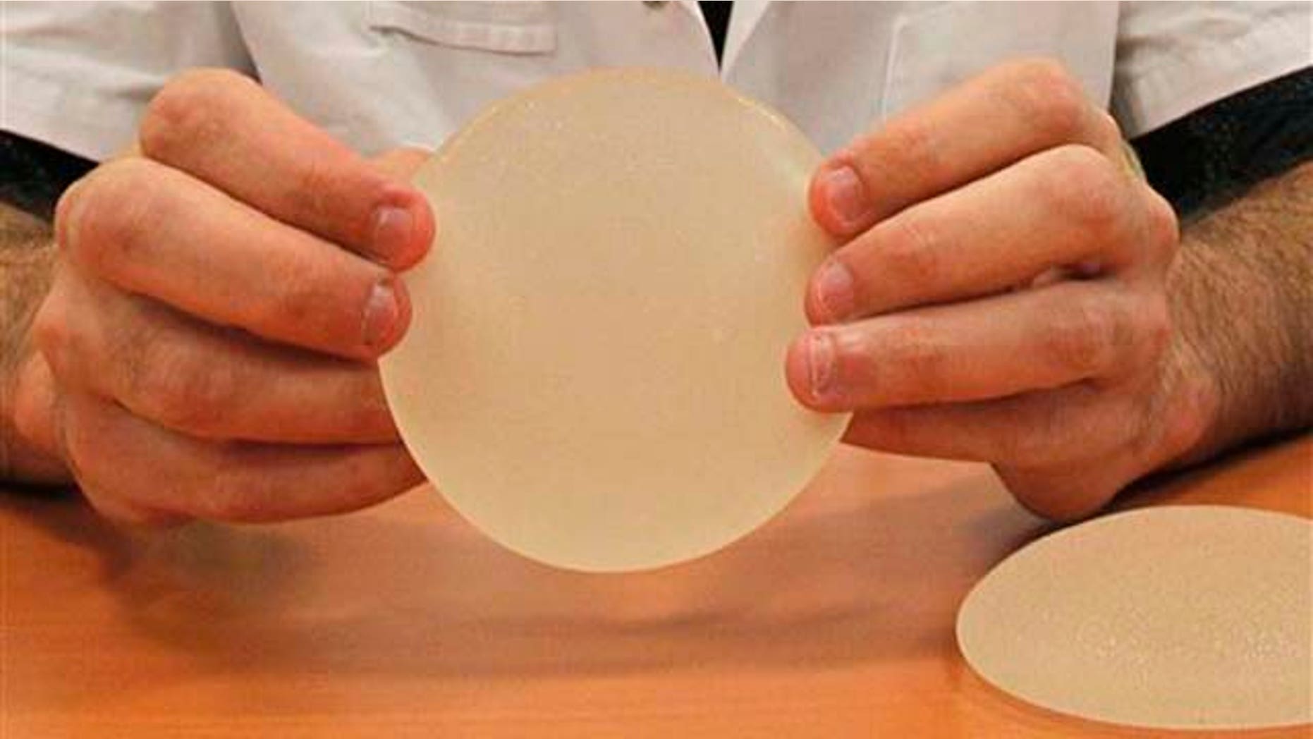 A plastic surgeon holds a silicone gel breast implant made by French company Poly Implant Prothese, or PIP, that he removed from a patient because of concerns that they are unsafe.