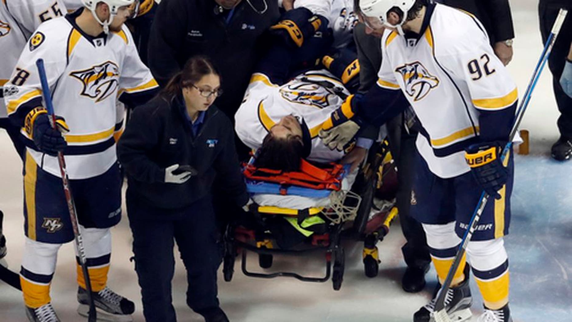 Nashville Predators' Ryan Johansen (92) and Viktor Arvidsson, left, of Sweden, offer encouragement to teammate Kevin Fiala, of Switzerland, as Fiala is taken off on a stretcher after being injured during the second period in Game 1 of an NHL hockey second-round playoff series against the St. Louis Blues, Wednesday, April 26, 2017, in St. Louis. (AP Photo/Jeff Roberson)