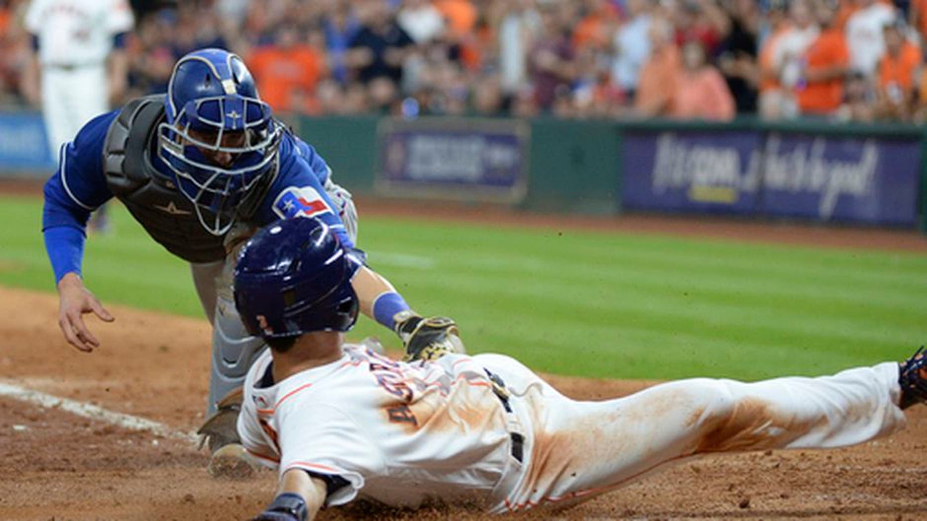 Houston Astros' Norichika Aoki slides safely into home before the tag by Texas Rangers catcher Jonathan Lucroy during the sixth inning of a baseball game Wednesday May 3, 2017, in Houston. (AP Photo/George Bridges)