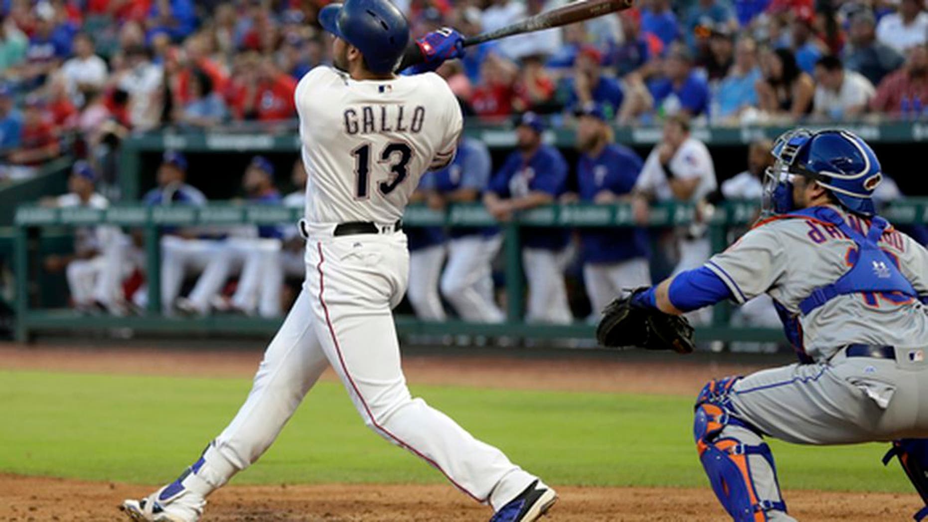 Texas Rangers' Joey Gallo (13) follows through on a two-run home run swing as New York Mets catcher Travis d'Arnaud watches in the third inning of an interleague baseball game, Tuesday, June 6, 2017, in Arlington, Texas. The shot scored Adrian Beltre in the 10-8 Rangers win. (AP Photo/Tony Gutierrez)