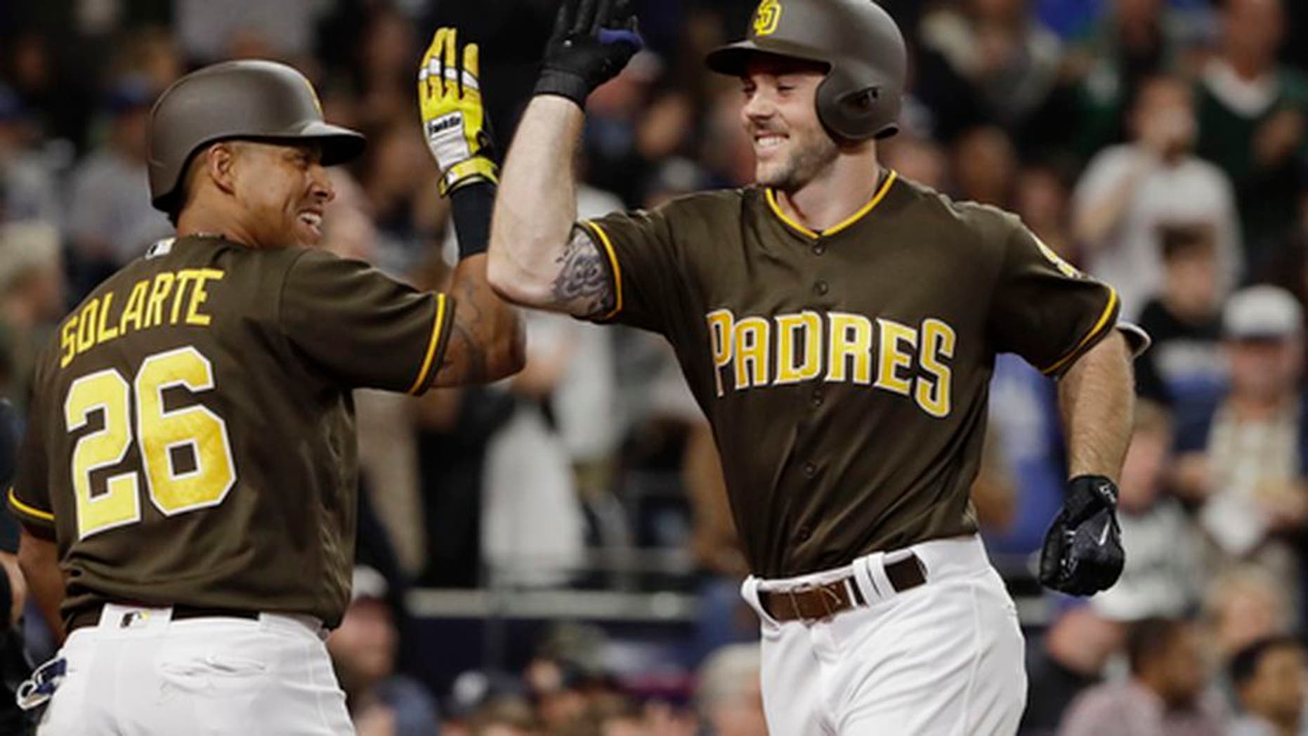 San Diego Padres' Matt Szczur, right, is greeted by Yangervis Solarte after hitting a home run during the seventh inning of the team's baseball game against the Kansas City Royals on Friday, June 9, 2017, in San Diego. (AP Photo/Gregory Bull)