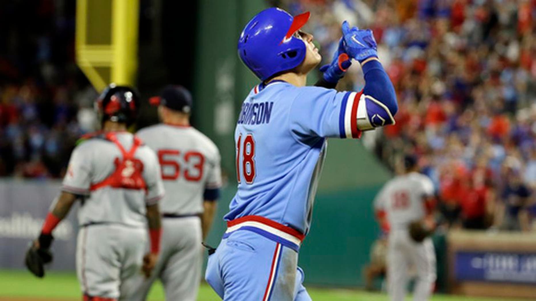 Texas Rangers' Drew Robinson (18) points skyward as he approaches the plate after hitting a two-run home run off Los Angeles Angels relief pitcher Blake Parker (53) during the sixth inning of a baseball game, Saturday, July 8, 2017, in Arlington, Texas. (AP Photo/Tony Gutierrez)