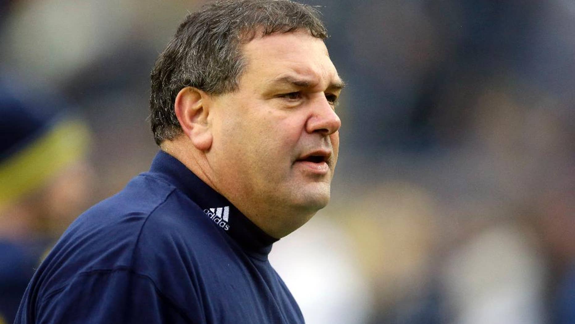 Michigan head coach Brady Hoke watches during warm-ups before an NCAA college football game against Maryland in Ann Arbor, Mich., Saturday, Nov. 22, 2014. (AP Photo/Carlos Osorio)