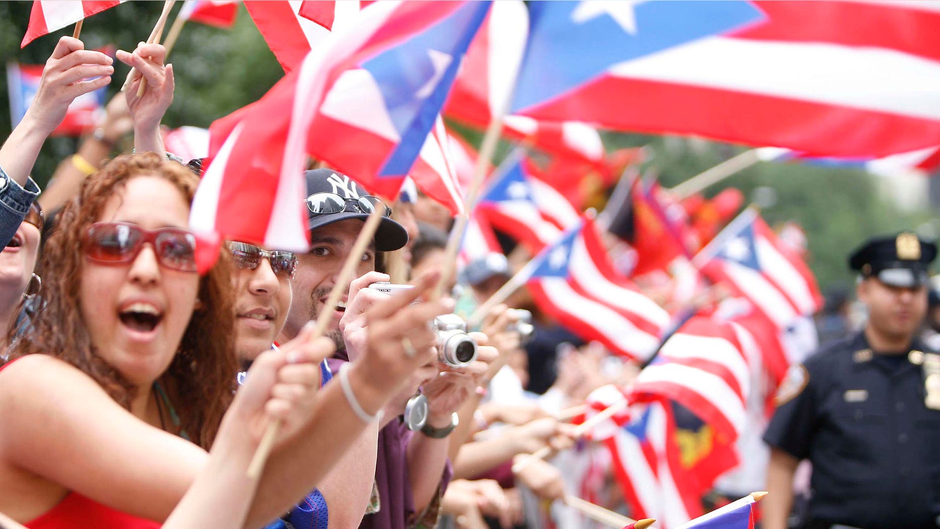 People wave flags during the 50th Anniversary of the National Puerto Rican Day Parade along 5th Avenue in 2007.