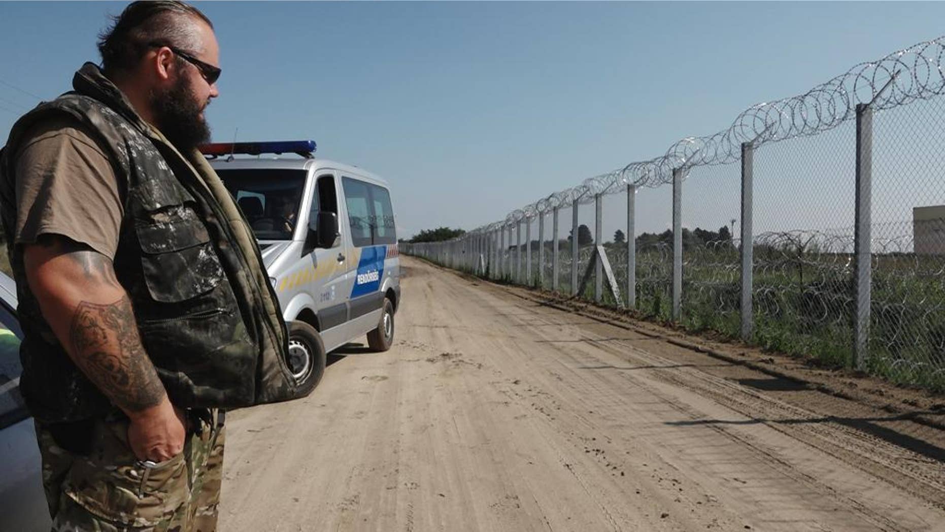 In this photo taken Wednesday, Sept. 14, 2016, ranger Zsolt Takacs guards the fence on Hungary’s border with Serbia, built last year to stop the flow of migrants and refugees from entering the country. Hungary, concerned that a new surge of migrants trying to reach the European Union could soon take place, is planning to reinforce the barrier with a new fence and surveillance equipment. (AP Photo/Andras Nagy)