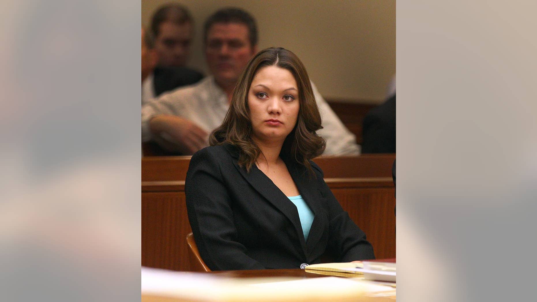 FILE - In this April 7, 2014 file photo, Dawn Nguyen listens as her attorney Matt Parrinello, delivers his opening statement to the jury during her trial in Rochester, N.Y. Nguyen was sentenced to eight years in federal prison Wednesday, Sept. 17, 2014 for supplying guns to a former neighbor who used them to kill his sister and two firefighters in a Christmas Eve ambush that also caused seven homes to burn to the ground. Nguyen, 25, pleaded guilty in June to three felonies, including supplying guns to a known felon. (AP Photo/Democrat & Chronicle, Jamie Germano, Pool)