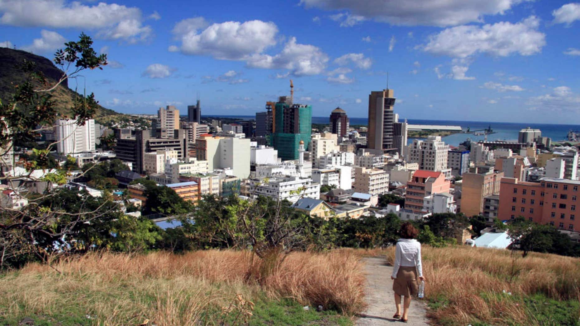 A woman walks down a hill to Port Louis, Mauritius