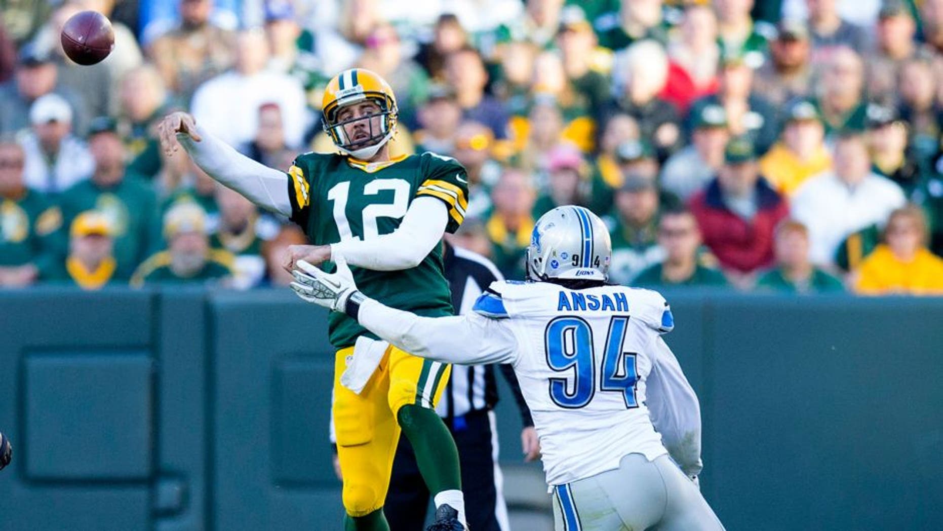 Nov 15, 2015; Green Bay, WI, USA; Green Bay Packers quarterback Aaron Rodgers (12) throws a pass under pressure from Detroit Lions defensive end Ezekiel Ansah (94) during the fourth quarter at Lambeau Field. Detroit won 18-16. Mandatory Credit: Jeff Hanisch-USA TODAY Sports