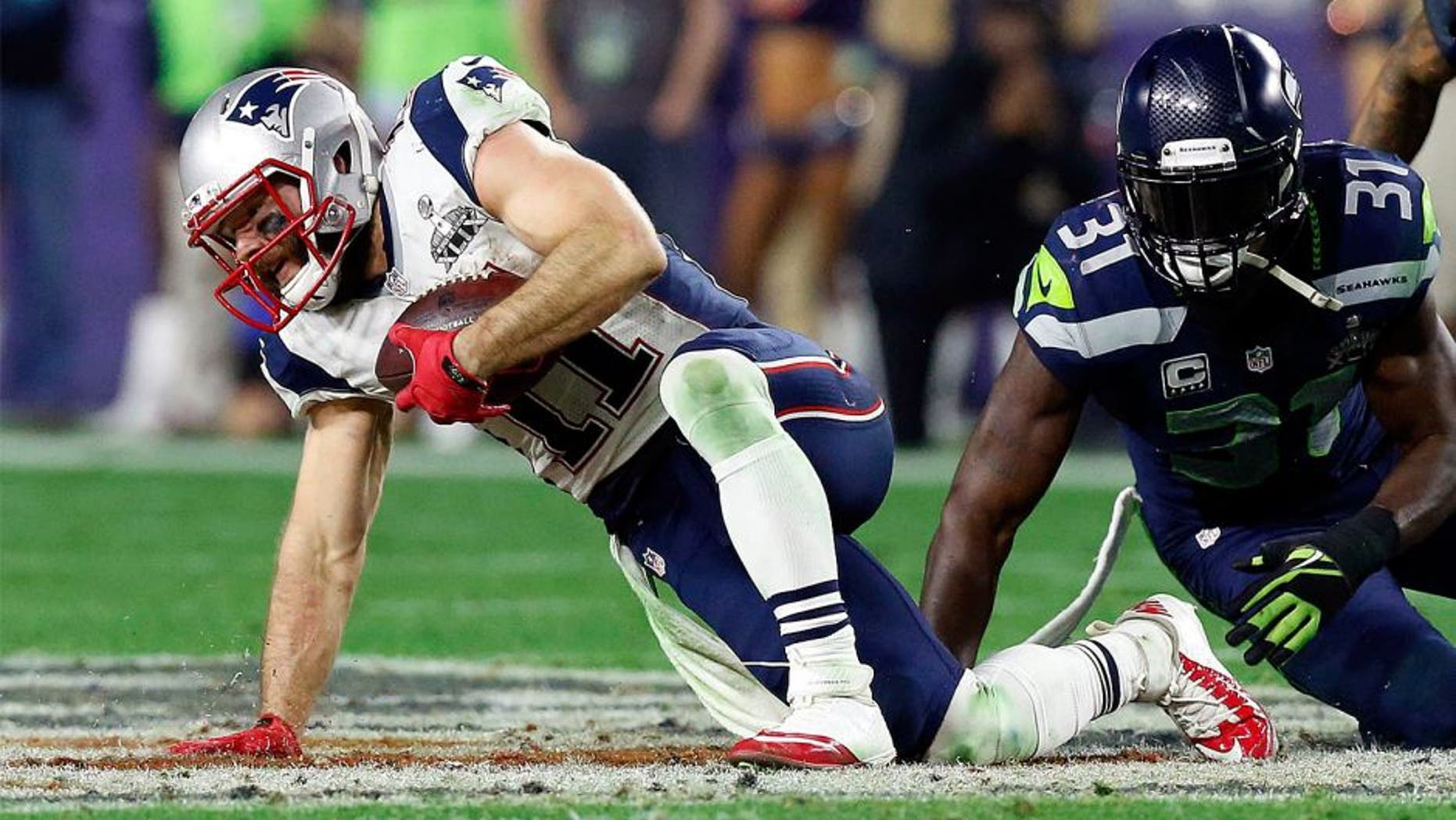Feb 1, 2015; Glendale, AZ, USA; New England Patriots wide receiver Julian Edelman (11) is tackled by Seattle Seahawks strong safety Kam Chancellor (31) during the fourth quarter in Super Bowl XLIX at University of Phoenix Stadium. Mandatory Credit: Matthew Emmons-USA TODAY Sports