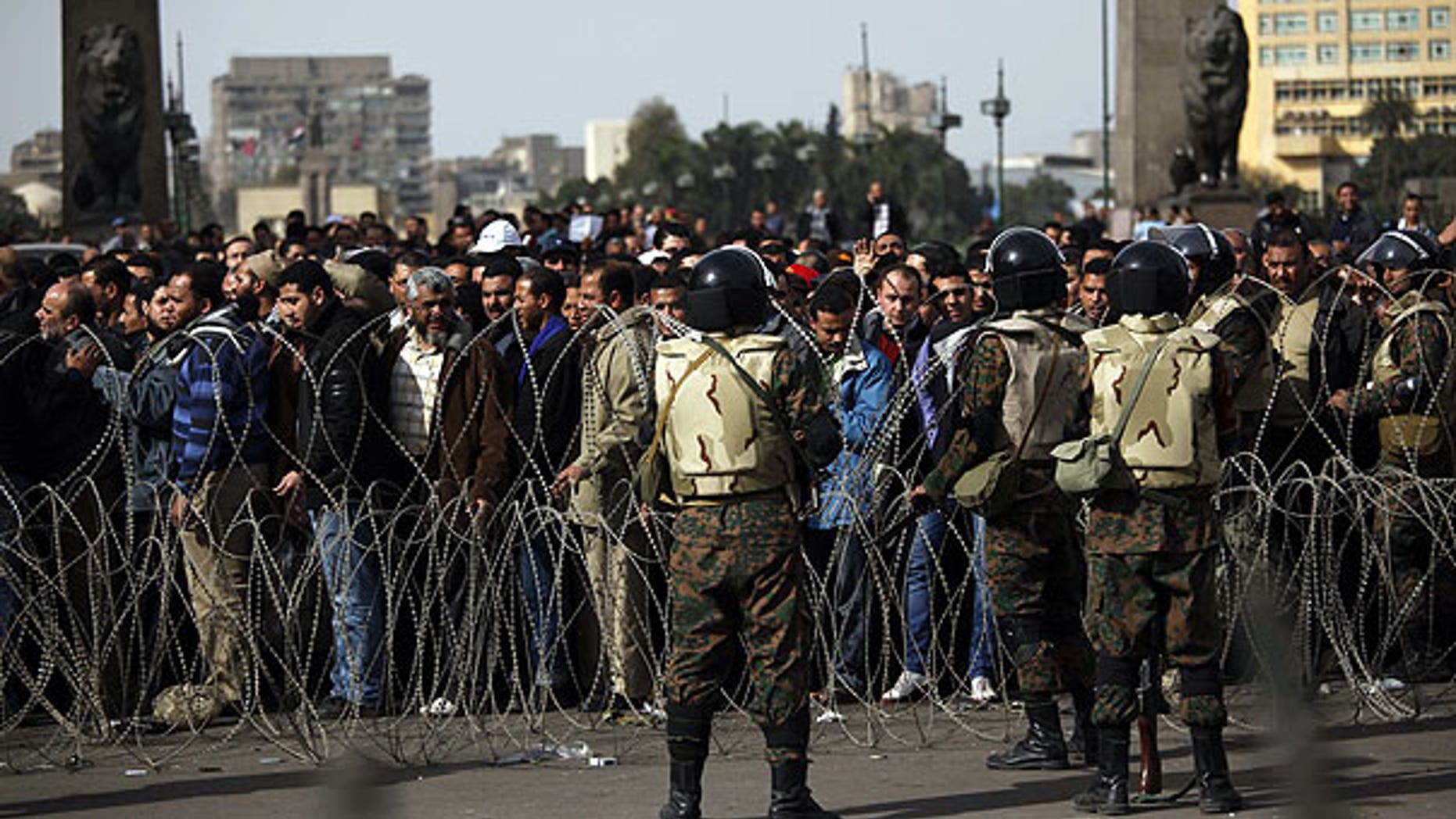 Feb. 4: Soldiers stand by as anti-government protesters line up to enter Tahrir Square, Cairo, Egypt.