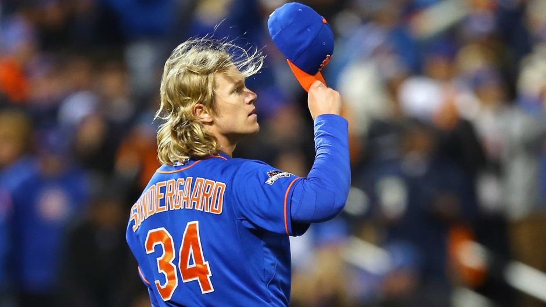 NEW YORK, NY - OCTOBER 18: Noah Syndergaard #34 of the New York Mets takes his hat off to celebrate Curtis Granderson #3 catching a pop up fly hit by Chris Coghlan #8 of the Chicago Cubs in the second inning during game two of the 2015 MLB National League Championship Series at Citi Field on October 18, 2015 in the Flushing neighborhood of the Queens borough of New York City. (Photo by Elsa/Getty Images)