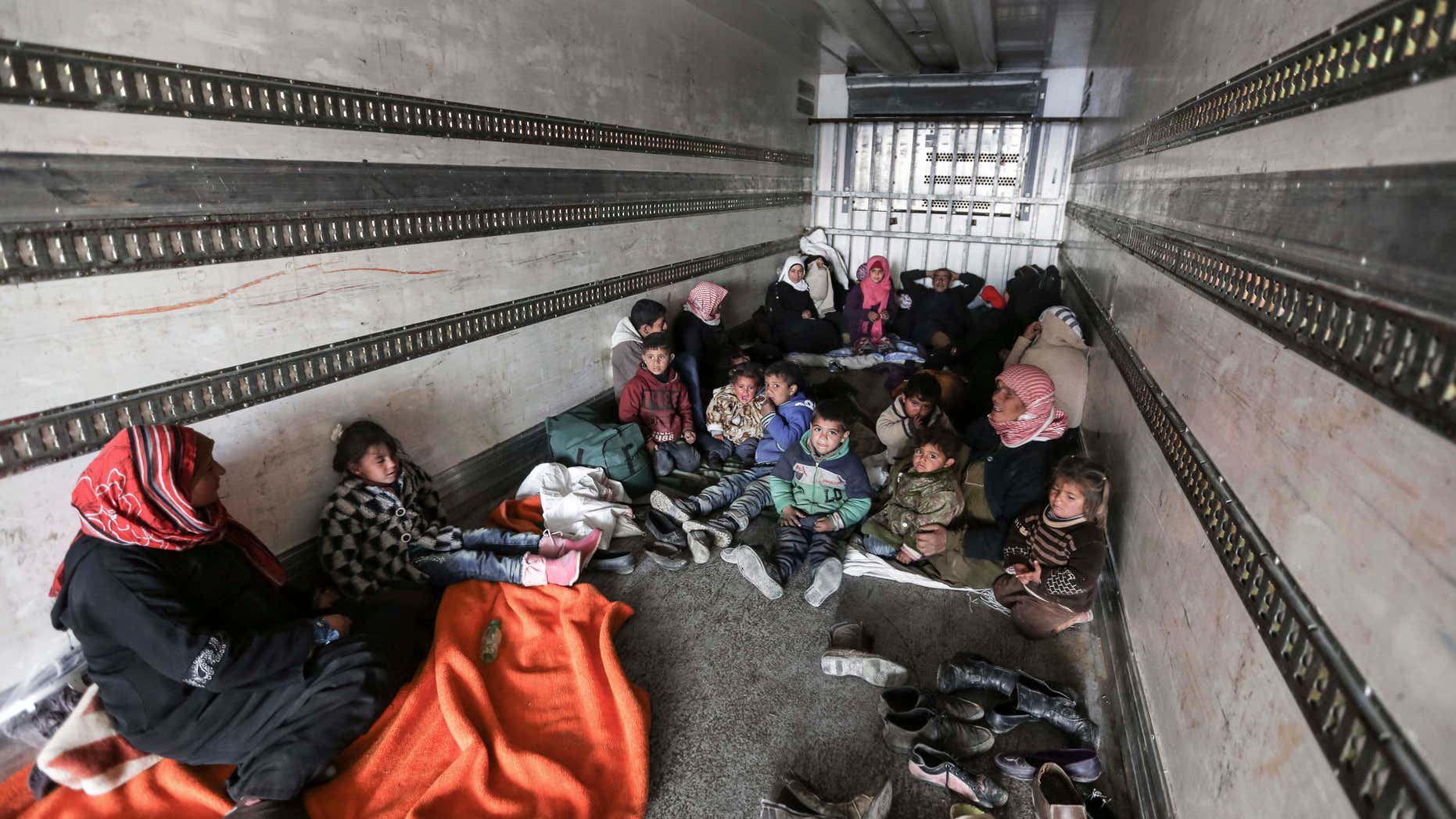 FEb. 6, 2016: Syrians gather inside a truck to protect themselves from the cold weather at the Bab al-Salam border gate with Turkey, in Syria.
