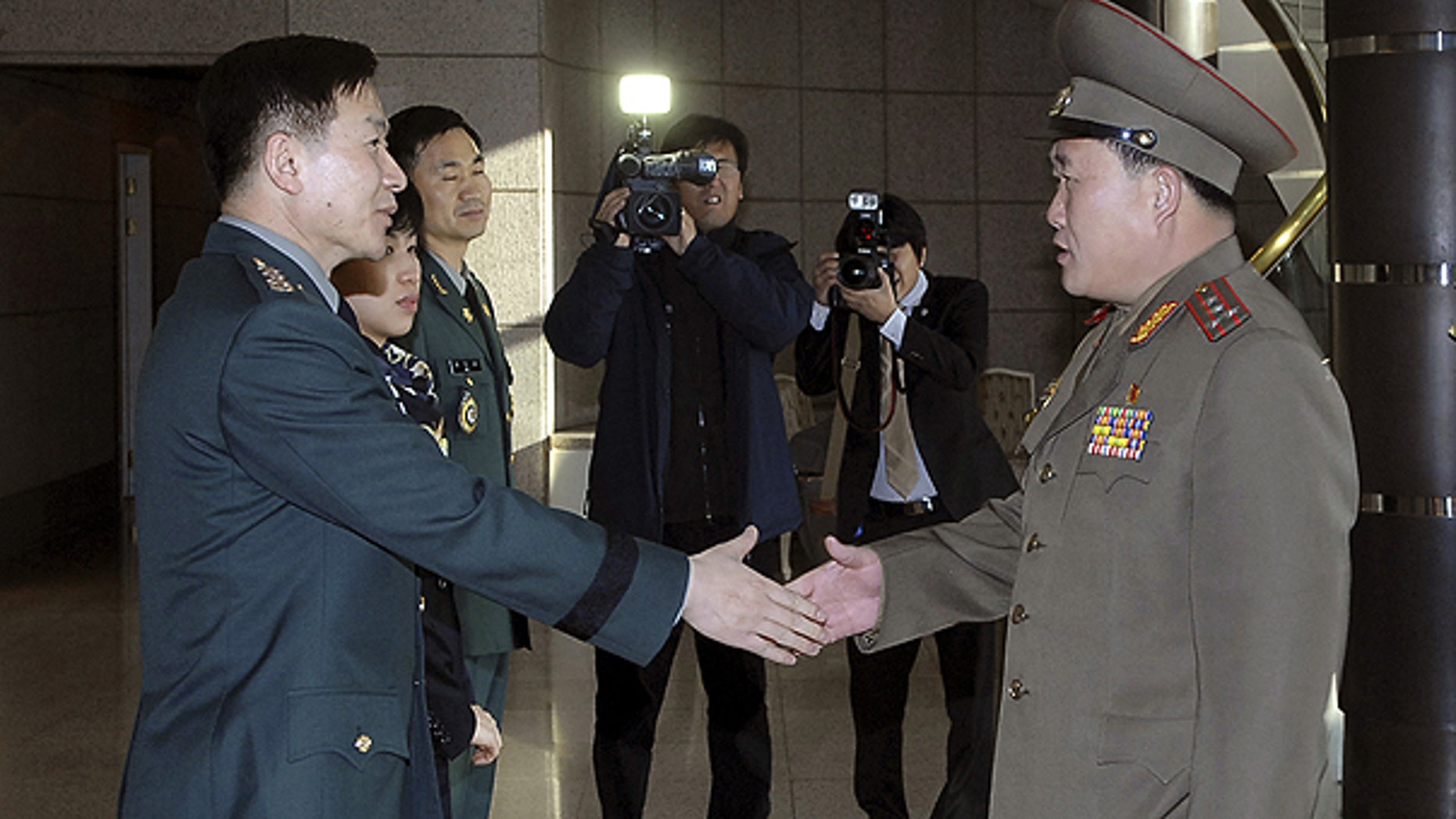 Feb. 9: In this photo released by the Defense Ministry, North Korean Army Col. Ri Sun Gyun, right, shakes hands with South Korean counterpart Col. Moon Sang-gyun upon his arrival for their military meeting at the south side of the truce village of Panmunjom in the demilitarized zone.