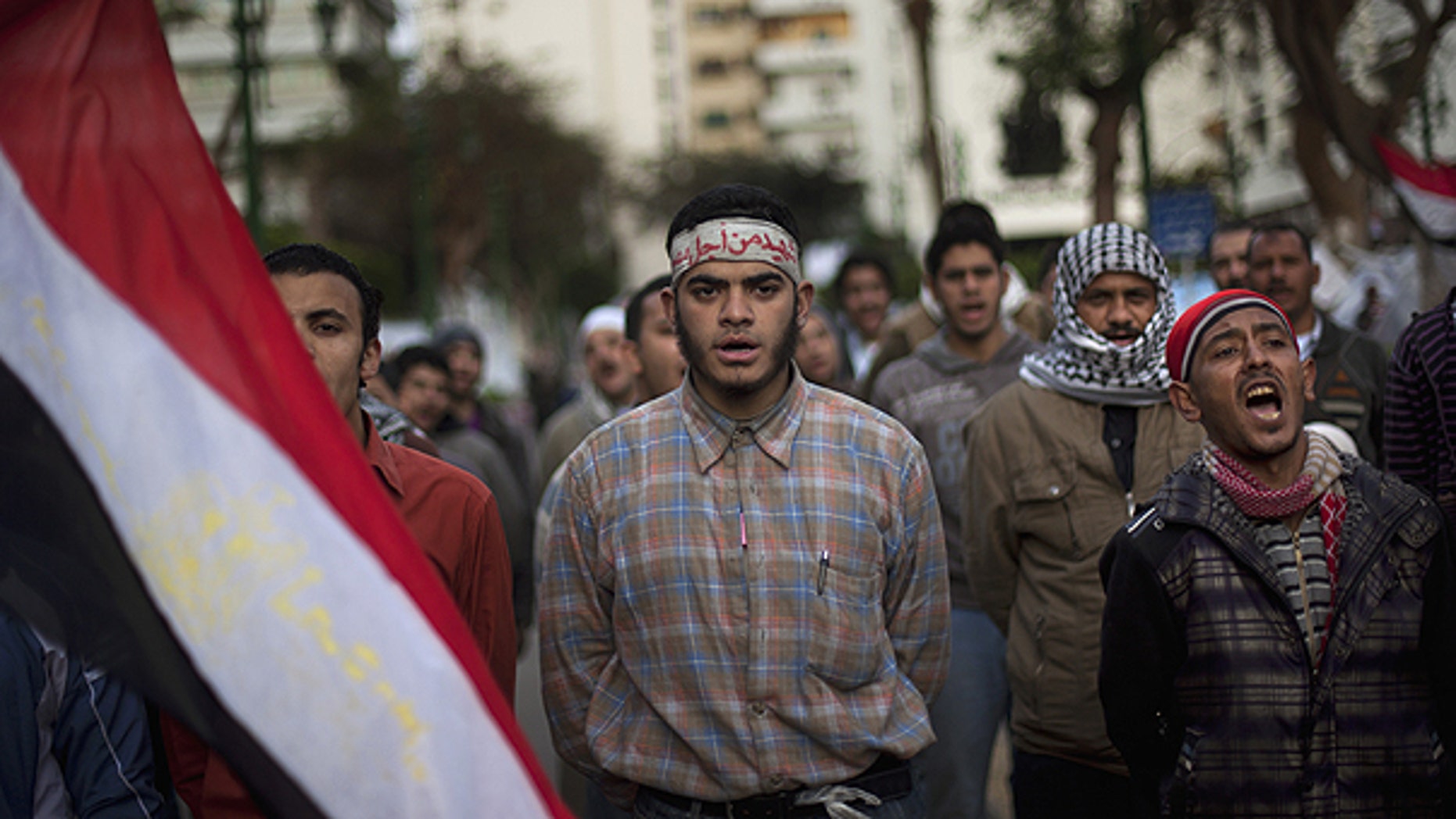 Feb. 10: Anti-government protesters shout slogans as they line up after spending the night in front of the Egyptian Parliament in Cairo, Egypt.