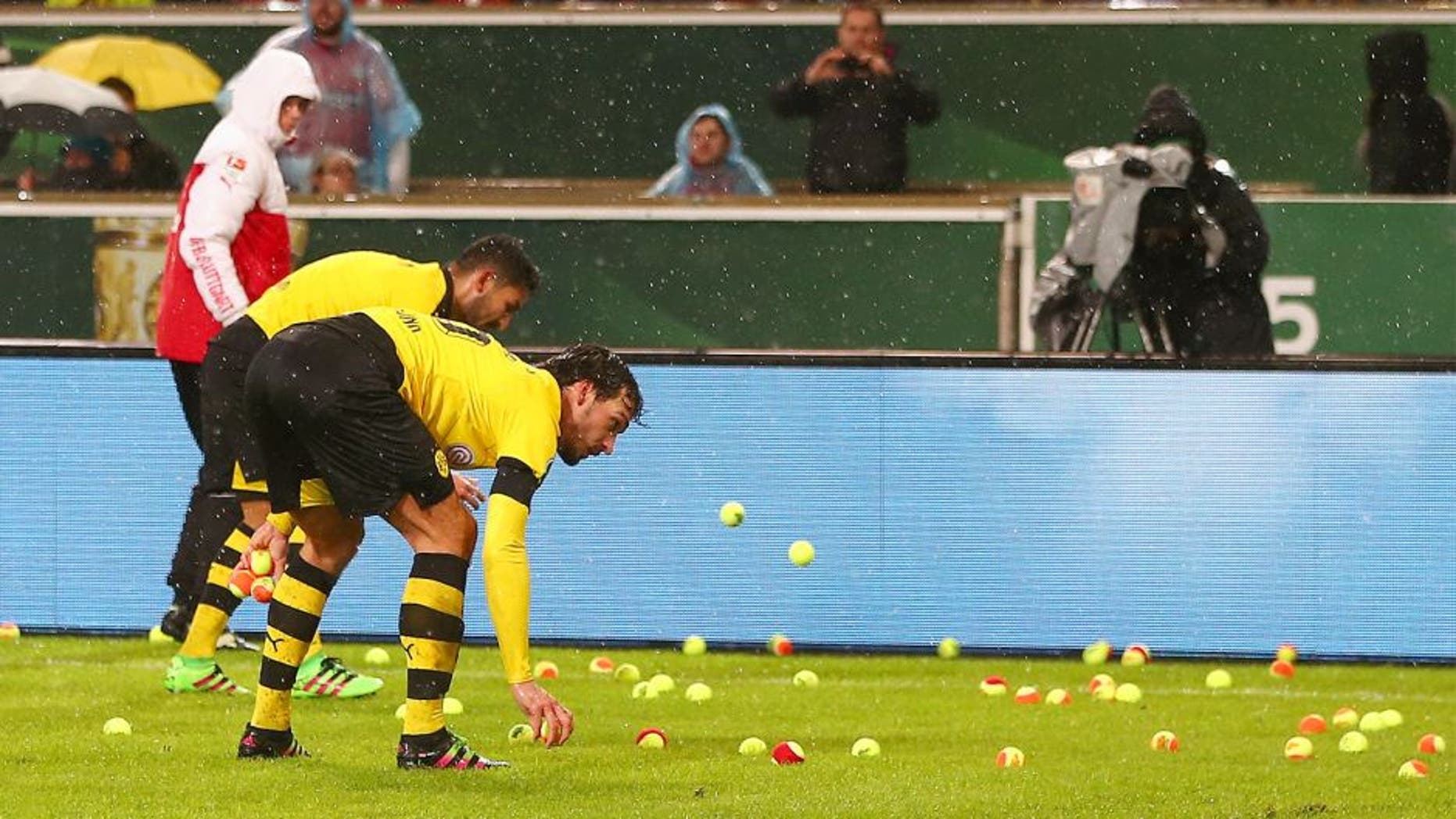 STUTTGART, GERMANY - FEBRUARY 09: Players remove tennis balls thrown by Dortmund fans from the pitch during the DFB Cup Quarter Final match between VfB Stuttgart and Borussia Dortmund at Mercedes-Benz Arena on February 9, 2016 in Stuttgart, Germany. (Photo by Alex Grimm/Bongarts/Getty Images)