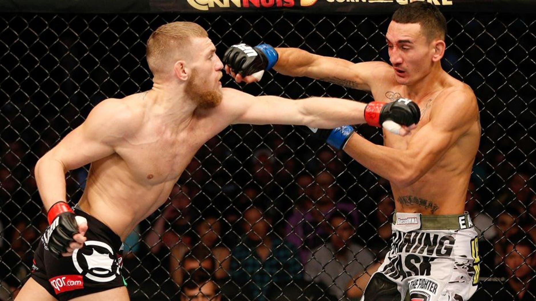 BOSTON, MA - AUGUST 17: (L-R) Conor McGregor punches Max Holloway in their UFC featherweight bout at TD Garden on August 17, 2013 in Boston, Massachusetts. (Photo by Josh Hedges/Zuffa LLC/Zuffa LLC via Getty Images)