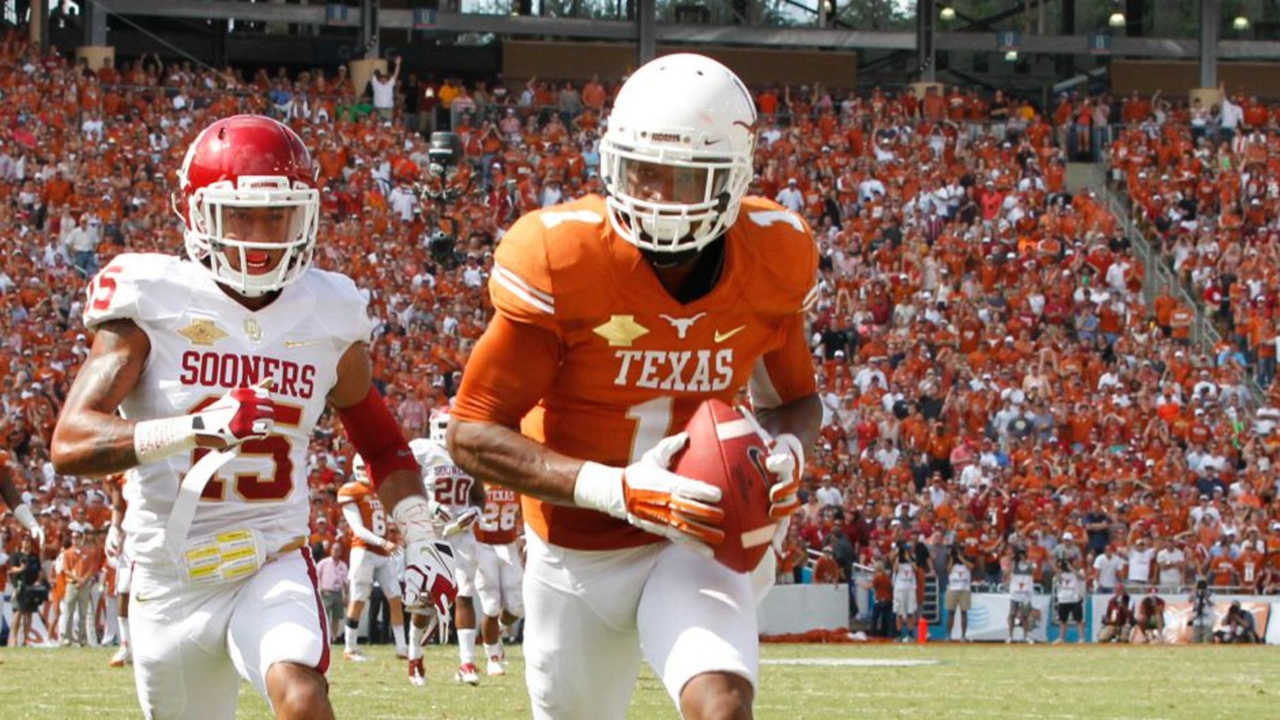 Oct 12, 2013; Dallas, TX, USA; Texas Longhorns wide receiver Mike Davis (1) scores a touchdown while being defended by Oklahoma Sooners defensive back Zack Sanchez (15) at the Red River Rivalry at Cotton Bowl Stadium. The Texas Longhorns beat the Oklahoma Sooners 36-20. Mandatory Credit: Tim Heitman-USA TODAY Sports