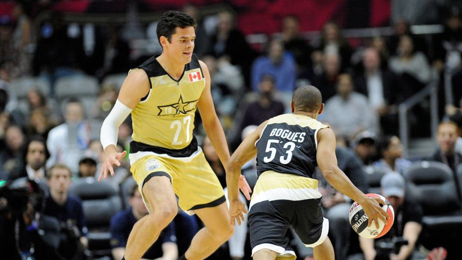 Feb 12, 2016; Toronto, Ontario, Canada; USA player Muggsy Bogues (5'3) is defended by Canada player Milos Raonic (27) during the All-Star celebrity basketball game at Ricoh Coliseum. Mandatory Credit: Peter Llewellyn-USA TODAY Sports