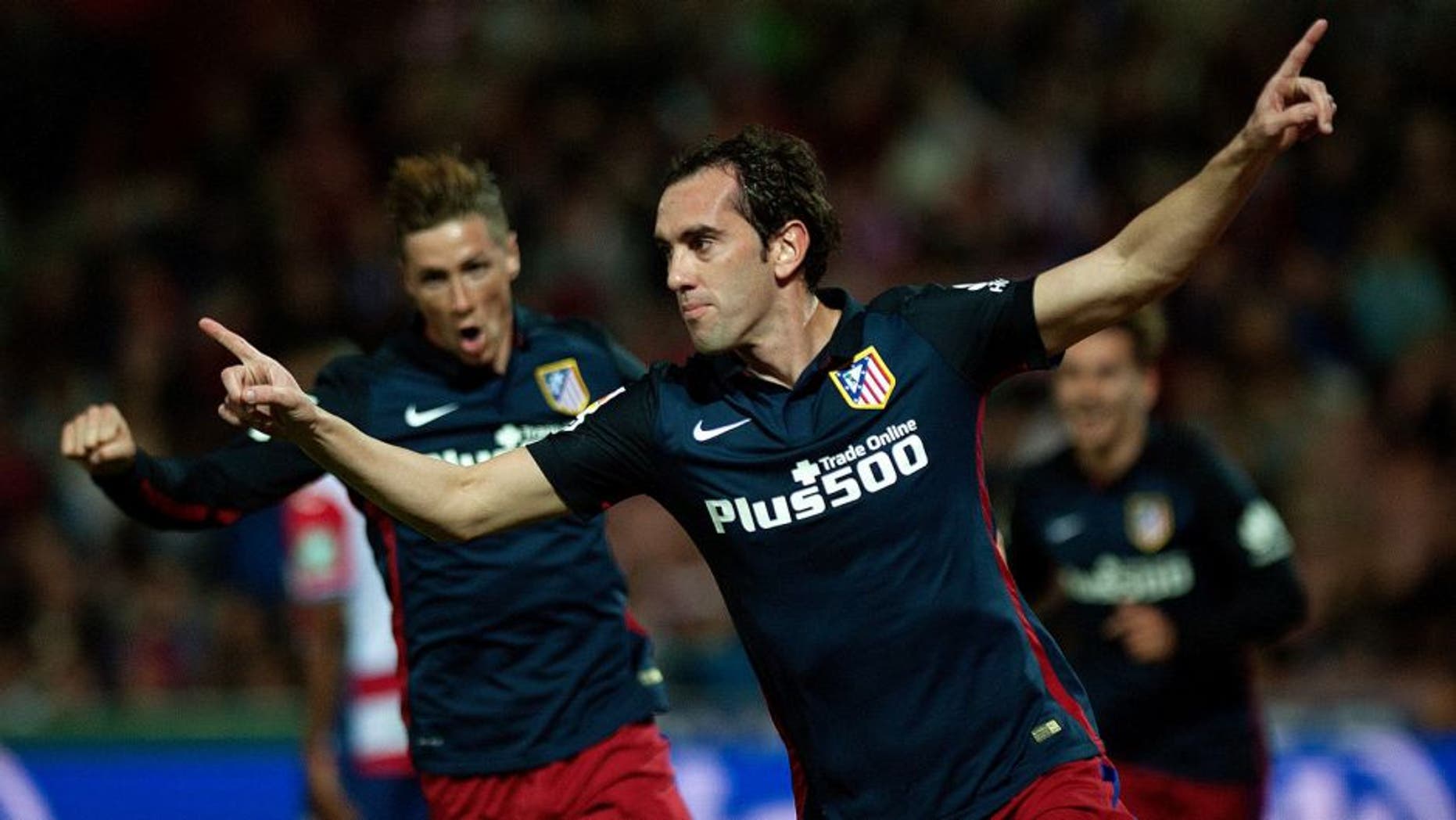 Atletico Madrid's Uruguayan defender Diego Godin (R) celebrates a goal during the Spanish league football match Granada FC VS Club Atletico de Madrid at Nuevo Los Carmenes stadium in Granada on December 5, 2015. AFP PHOTO / JORGE GUERRERO / AFP / Jorge Guerrero (Photo credit should read JORGE GUERRERO/AFP/Getty Images)