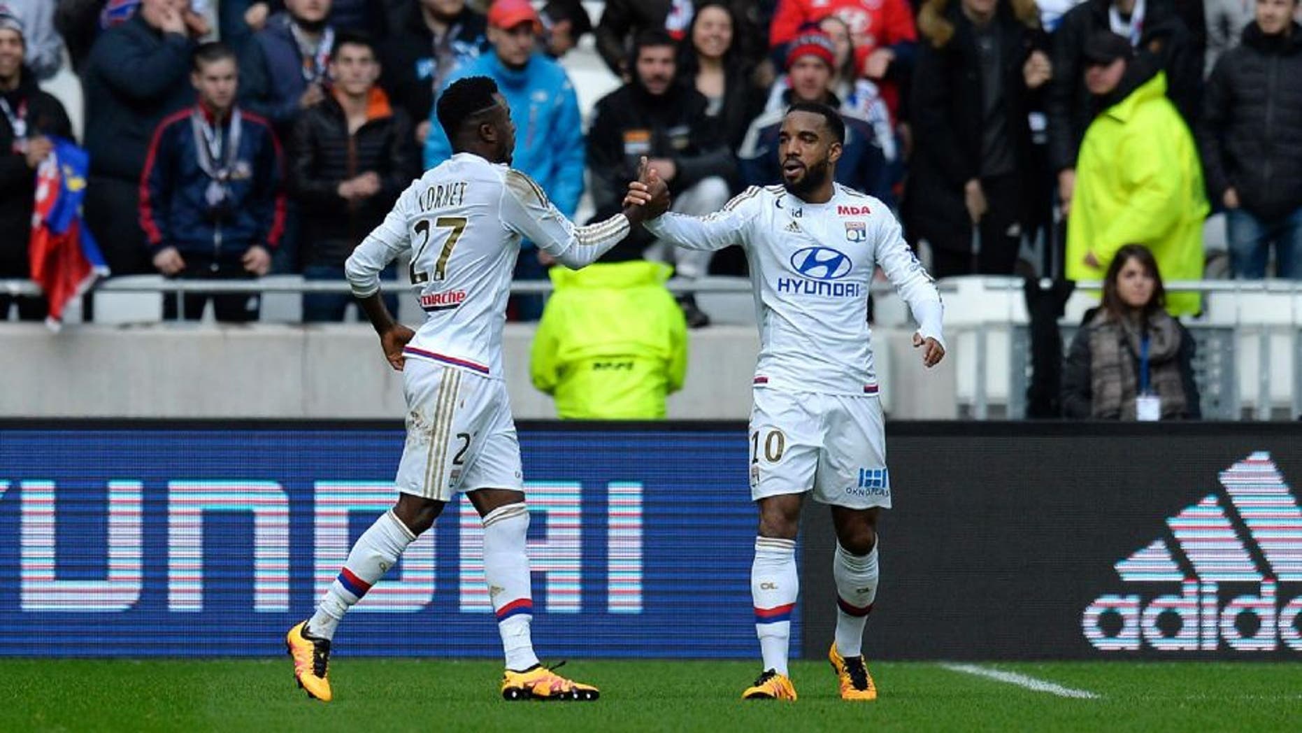 Lyon's French forward Maxwell Cornet (L) celebrates after scoring a goal with Lyon's French forward Alexandre Lacazette during the French L1 football match between Olympique Lyonnais (OL) and Stade Malherbe Caen (SMC) at the Parc Olympique Lyonnais stadium in Decines-Charpieu, central-eastern France on February 14, 2016. / AFP / ROMAIN LAFABREGUE (Photo credit should read ROMAIN LAFABREGUE/AFP/Getty Images)