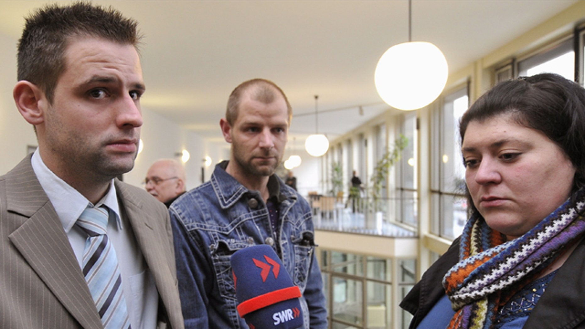 Feb. 15: Bjoern B., left, and Markus S., both stepsons of Detlef S., and B.'s wife Nadja, give interviews outside the courtroom in the regional court in Koblenz, western Germany.