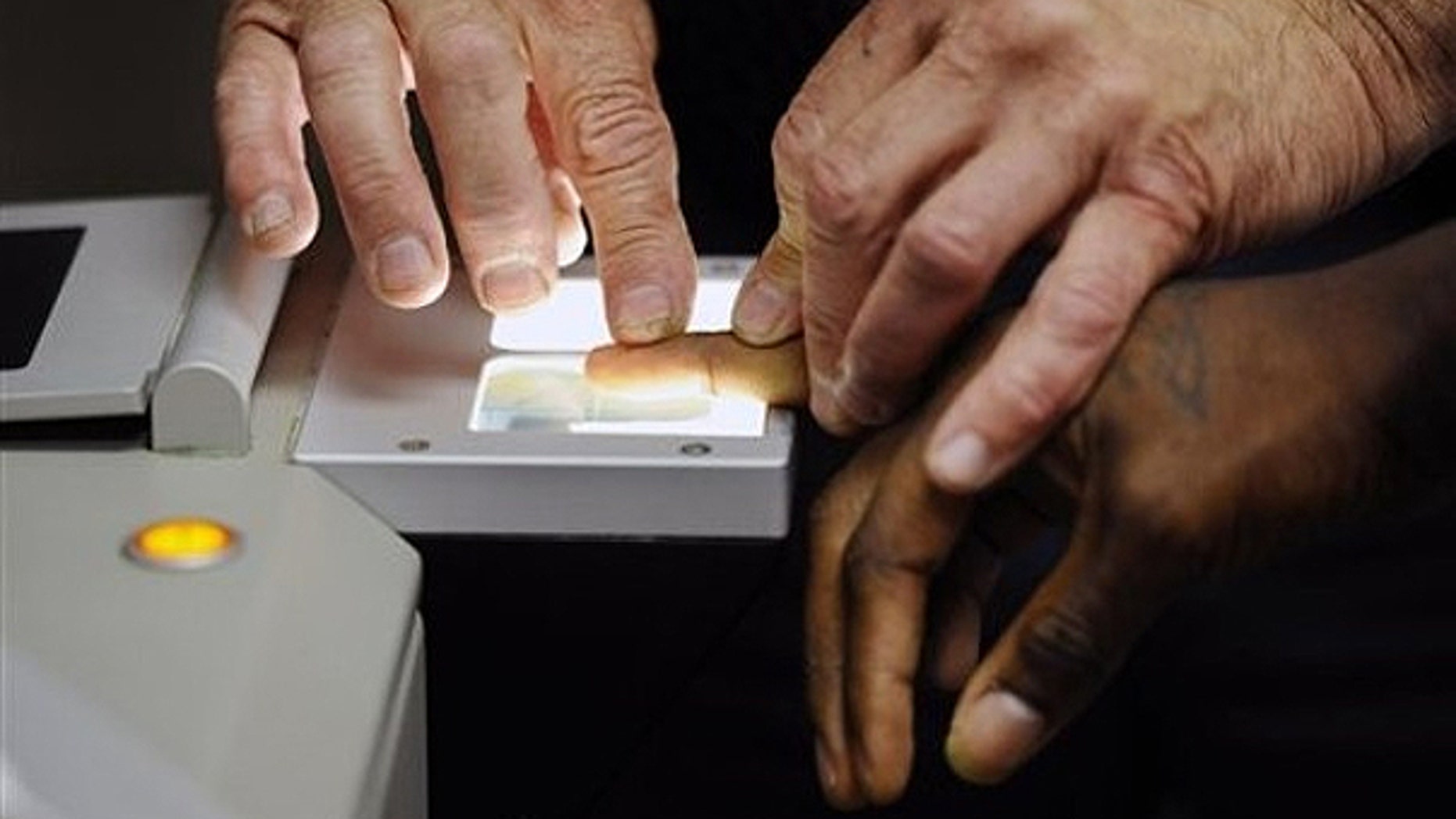 July 26, 2010: Senior Deputy Jerry Anttila fingerprints an unidentified suspect during the booking process at the Arapahoe County Justice Center in Centennial, Colo.