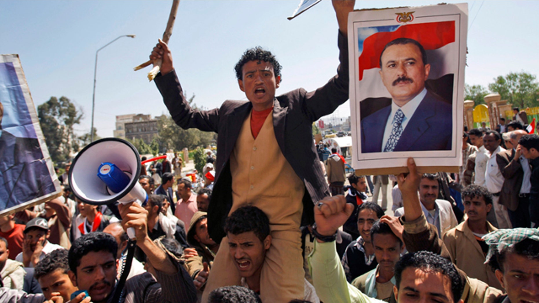 Feb. 16: Supporters of the Yemeni government shout slogans as they try to enter Sanaa University where anti-government protestors gather, in Sanaa, Yemen.
