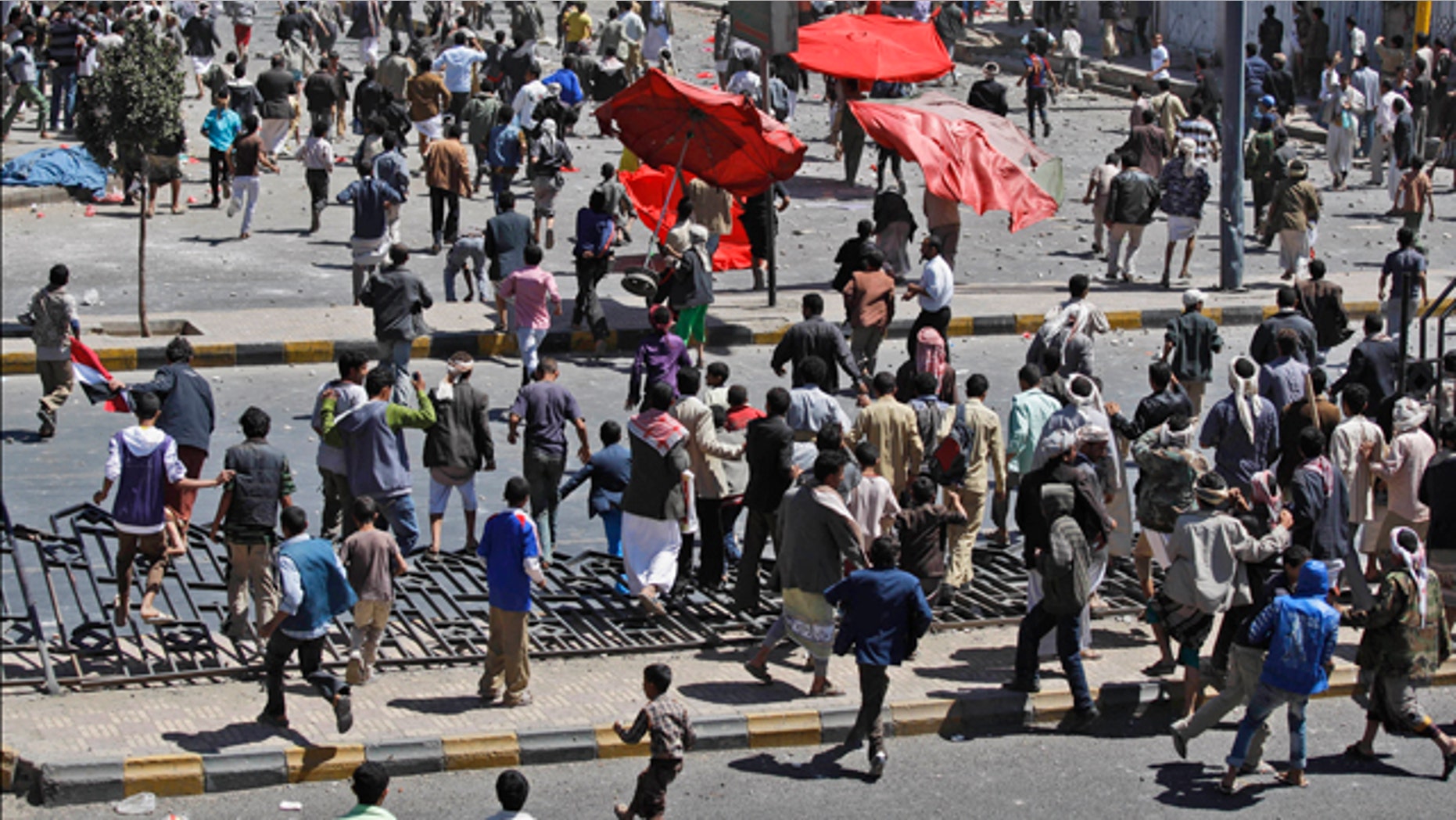 Feb. 17: Supporters of the Yemeni government, below, chase after anti-government demonstrators, top, during clashes in Sanaa, Yemen.