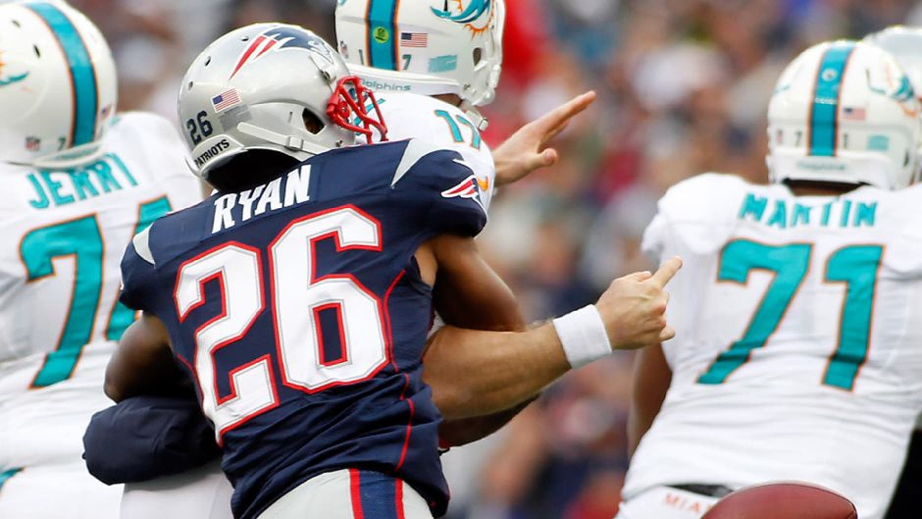 Oct 27, 2013; Foxborough, MA, USA; New England Patriots cornerback Logan Ryan (26) strip sacks Miami Dolphins quarterback Ryan Tannehill (17) during the third quarter at Gillette Stadium. Mandatory Credit: Stew Milne-USA TODAY Sports